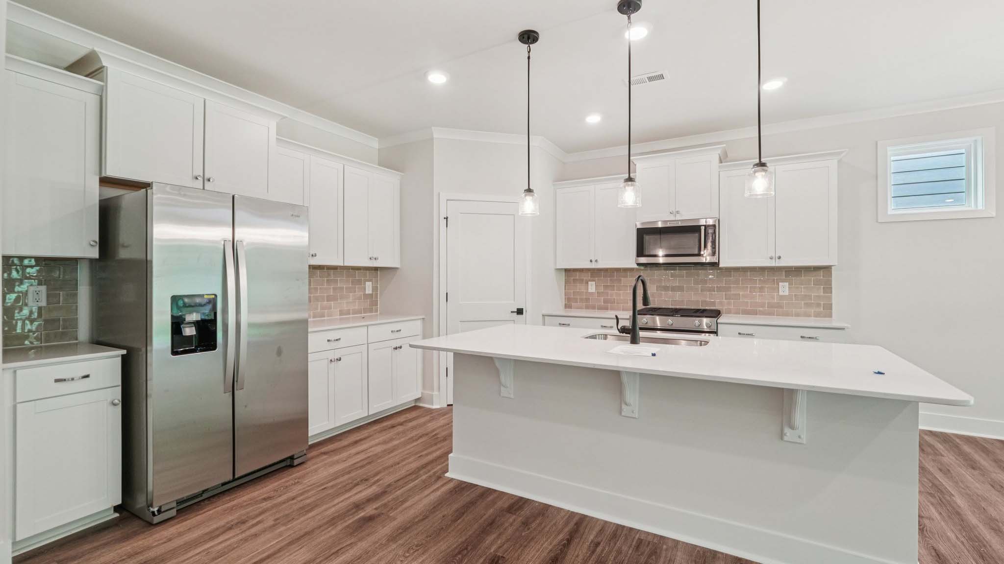 Kitchen and Island with white cabinets and stainless steel appliances