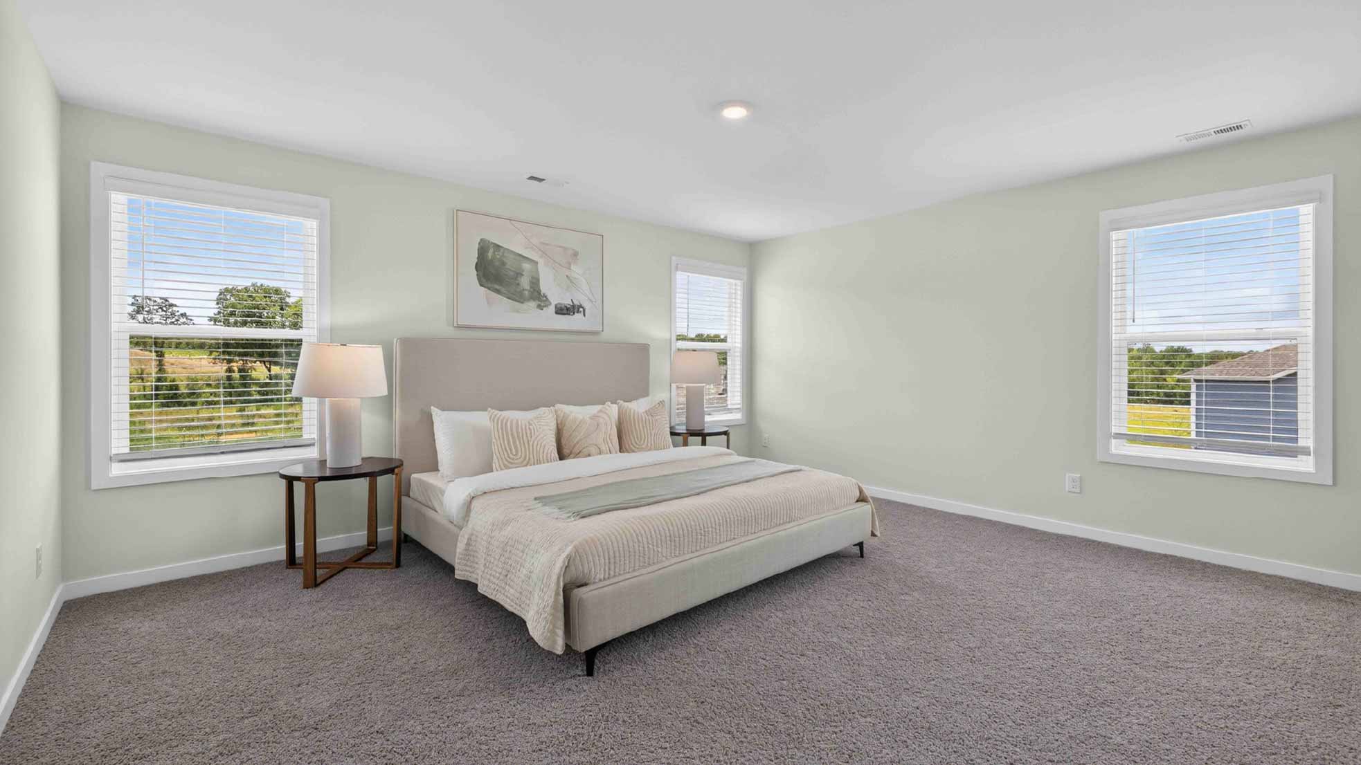 Primary carpeted bedroom with windows