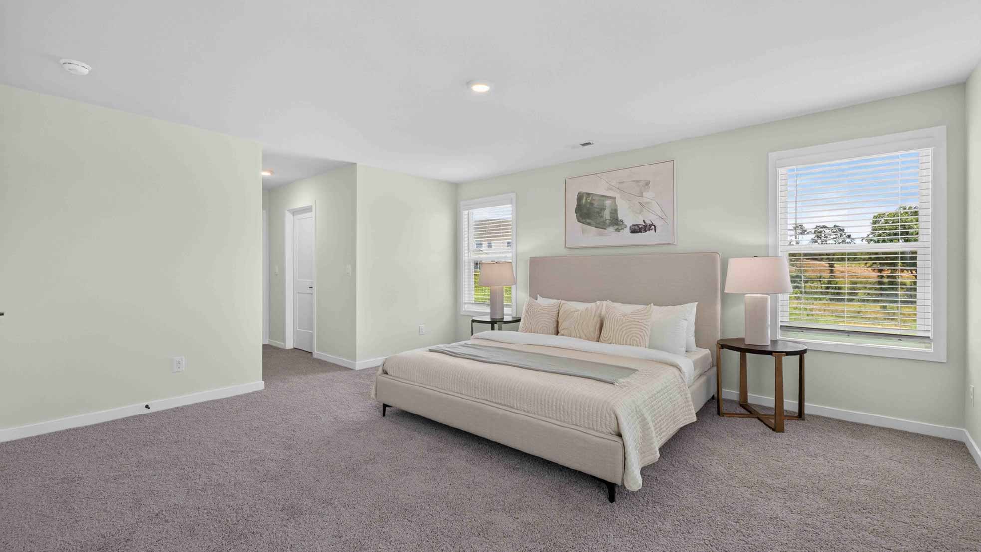 Primary carpeted bedroom with windows
