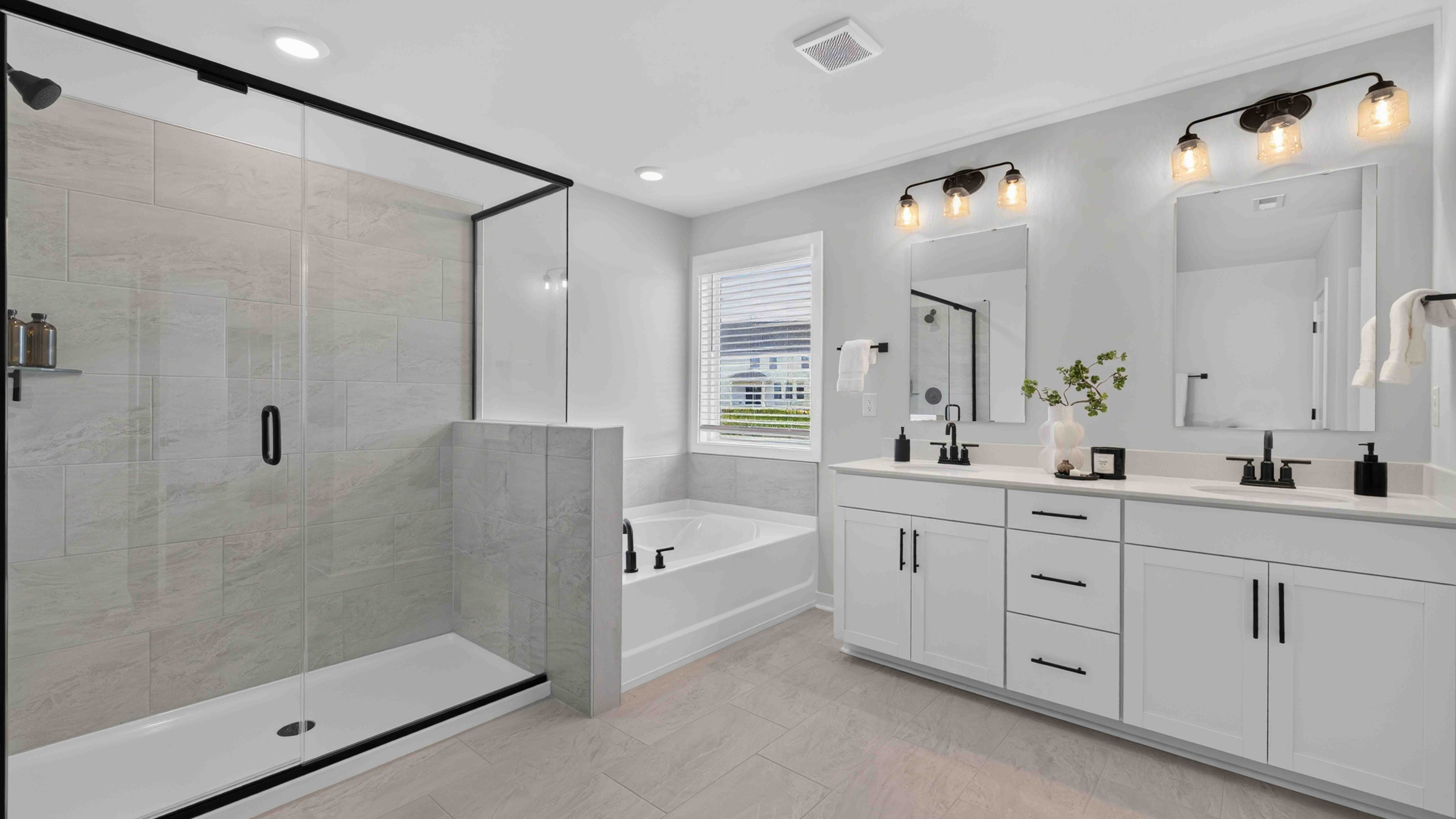 Primary bathroom with standing glass shower and double sinks
