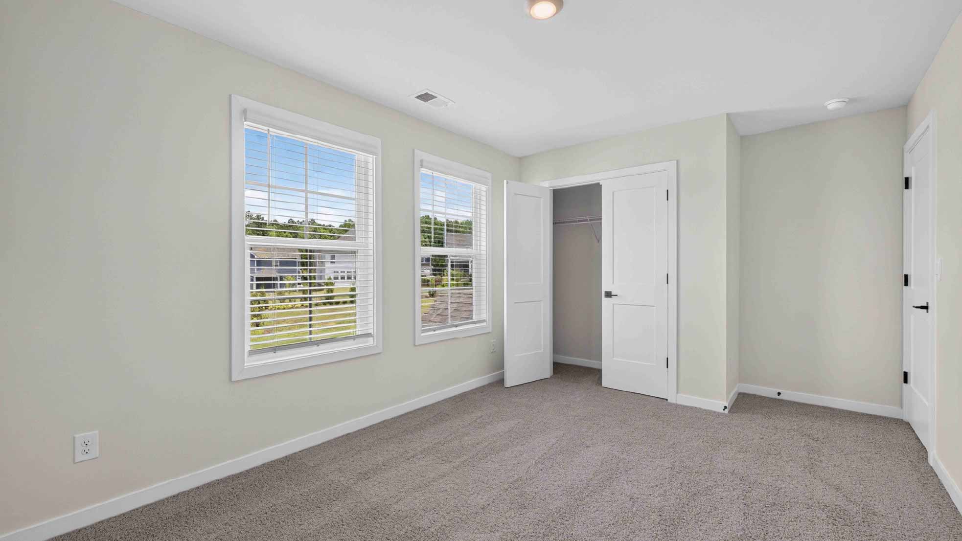 Carpeted bedroom with windows