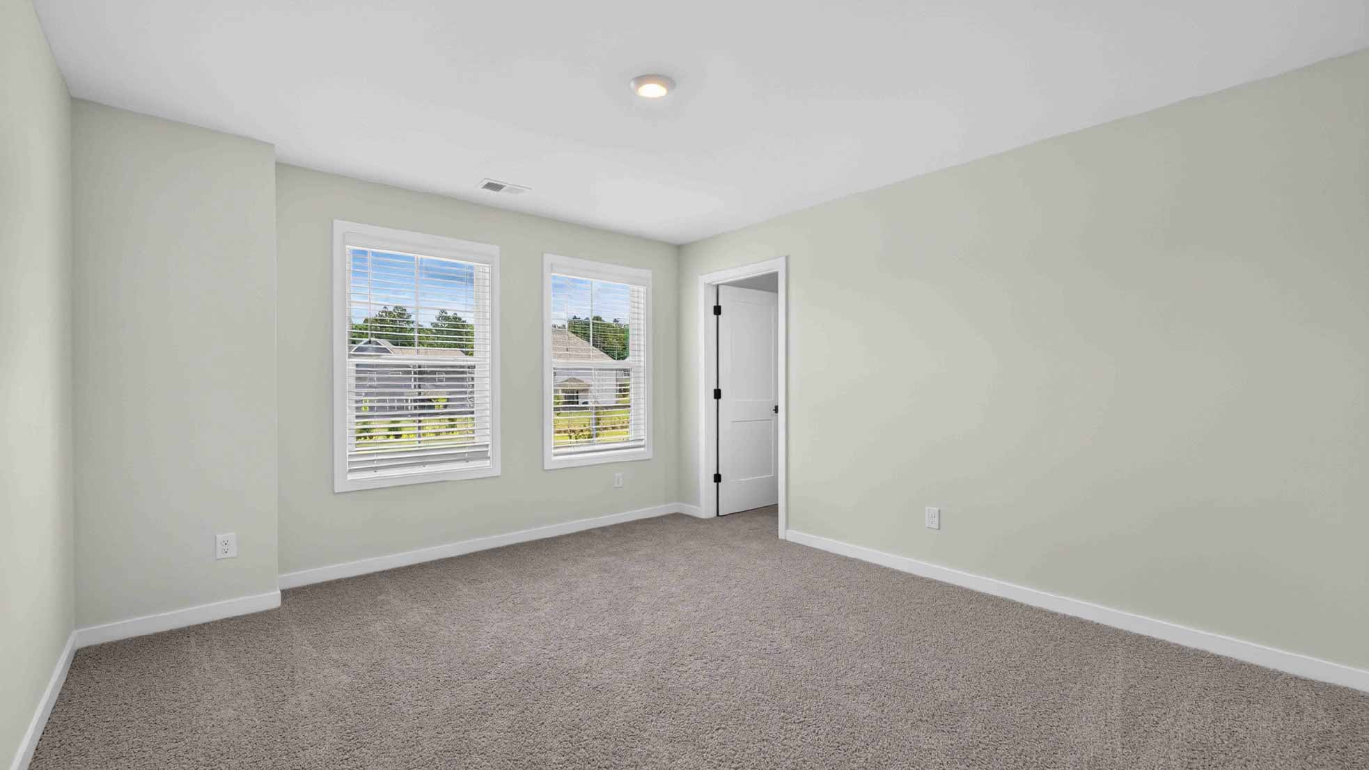 Carpeted bedroom with windows