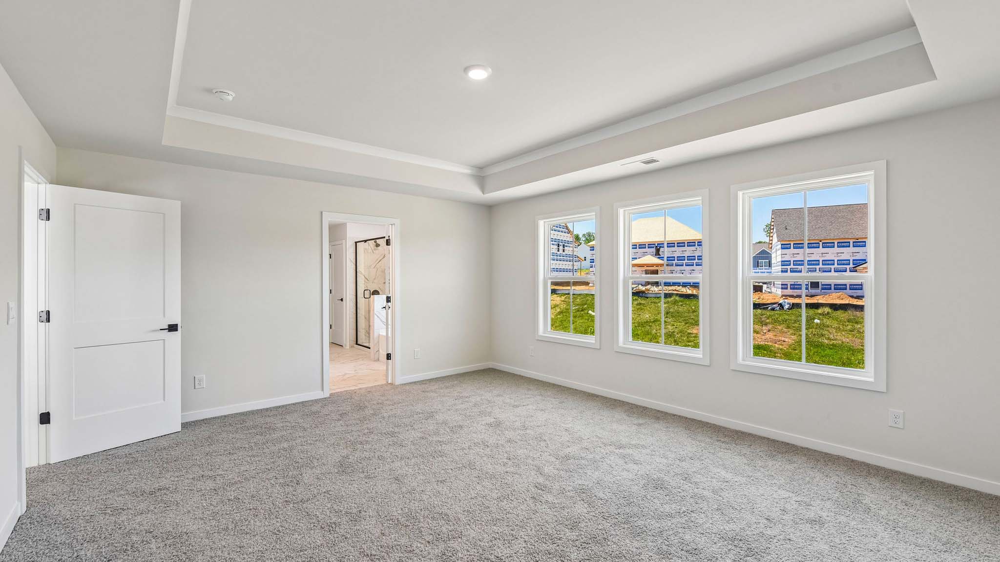 Primary carpeted bedroom with windows