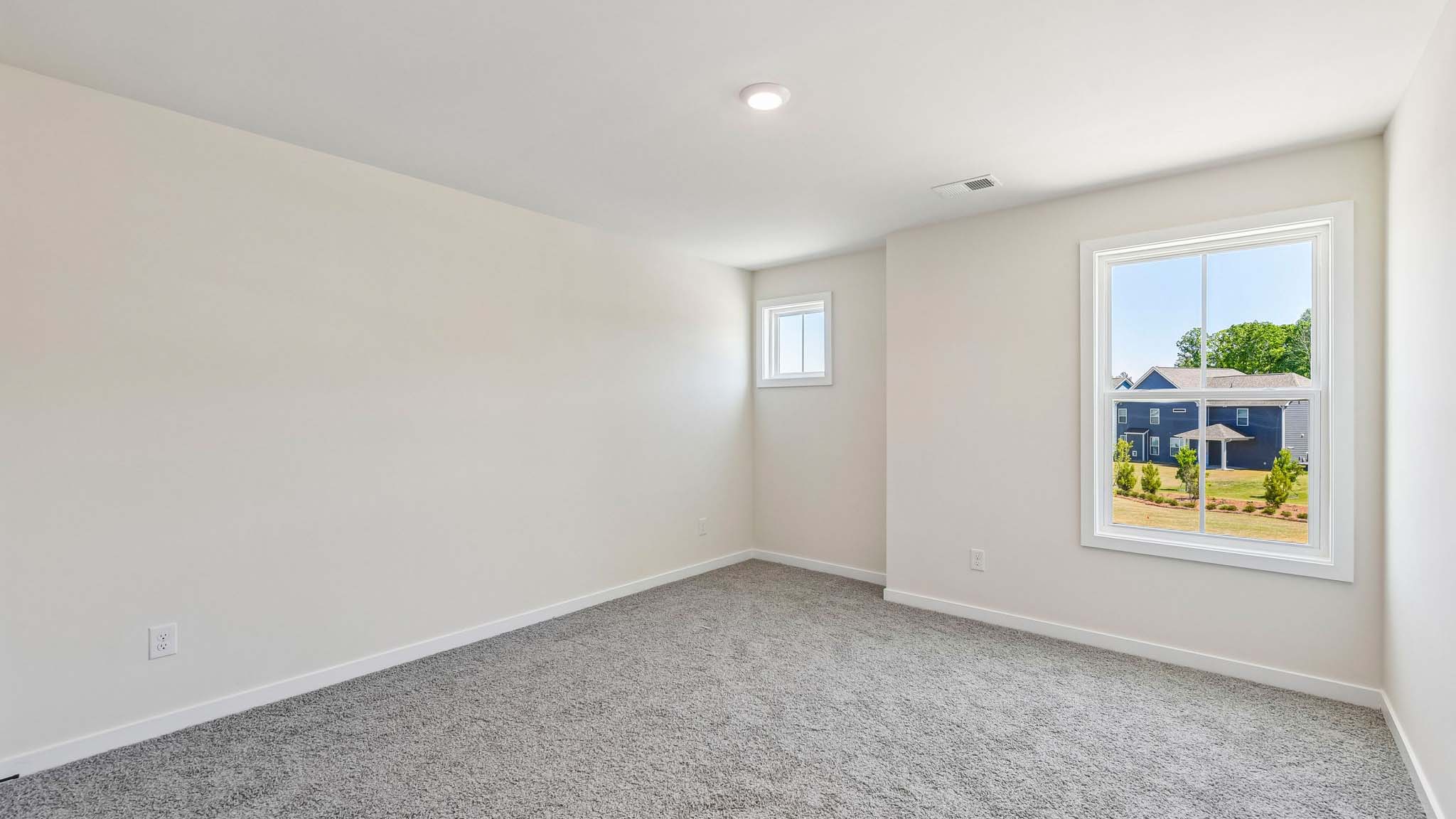 Carpeted bedroom with windows