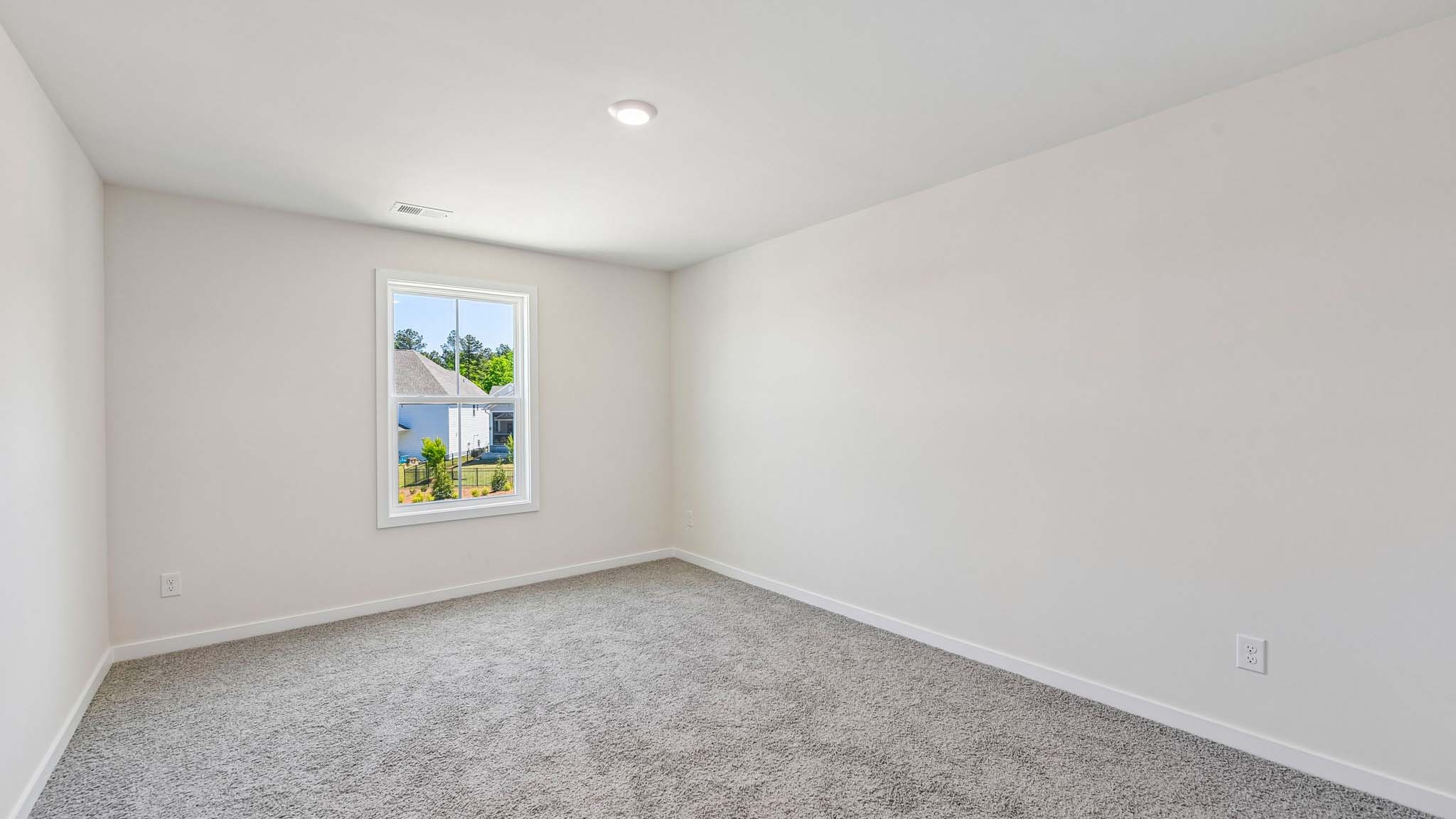 Carpeted bedroom with windows