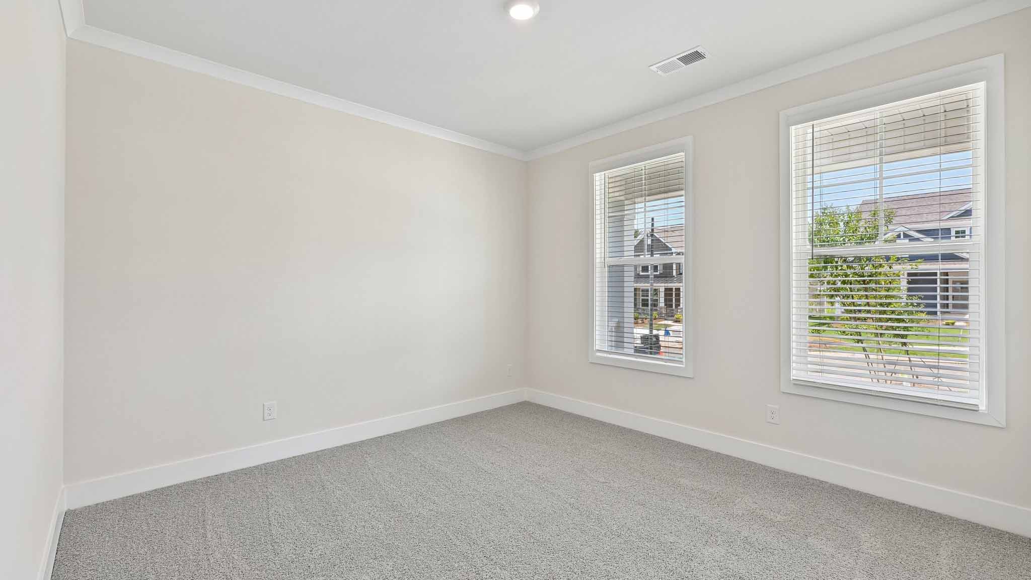 Carpeted bedroom with windows