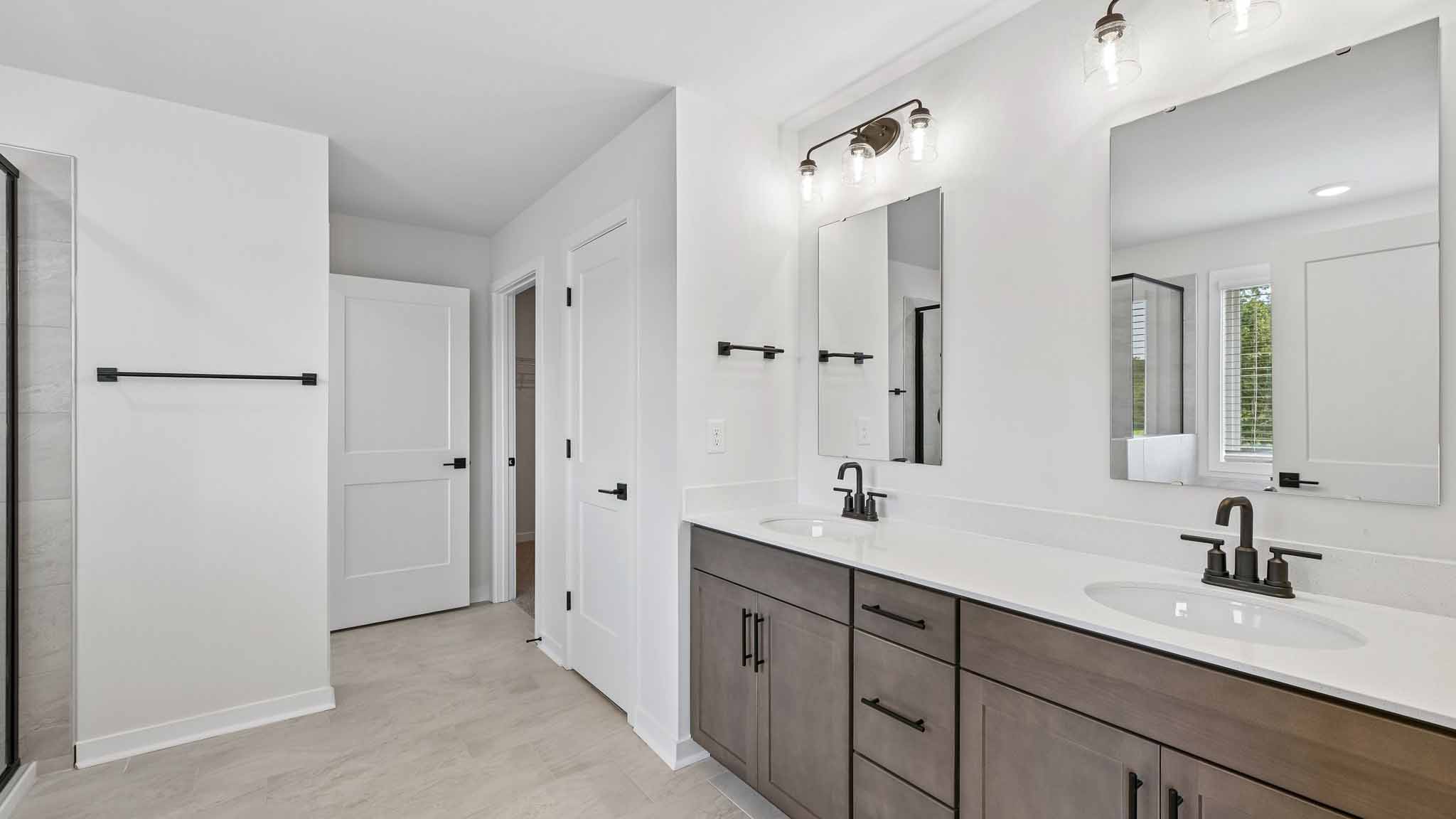 Primary bathroom with brown cabinets and standing tub and standing glass shower
