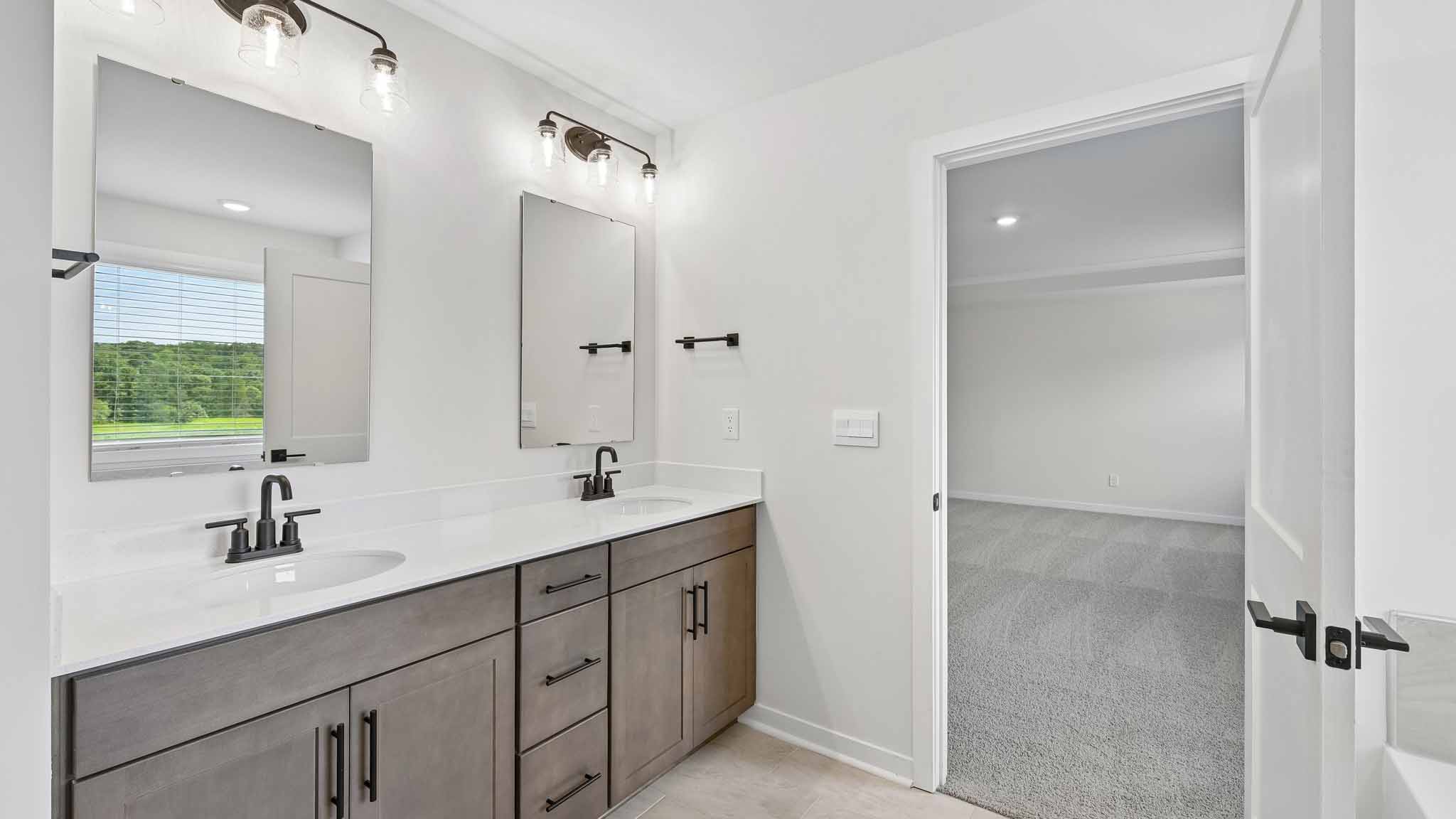 Primary bathroom with brown cabinets and standing tub and standing glass shower