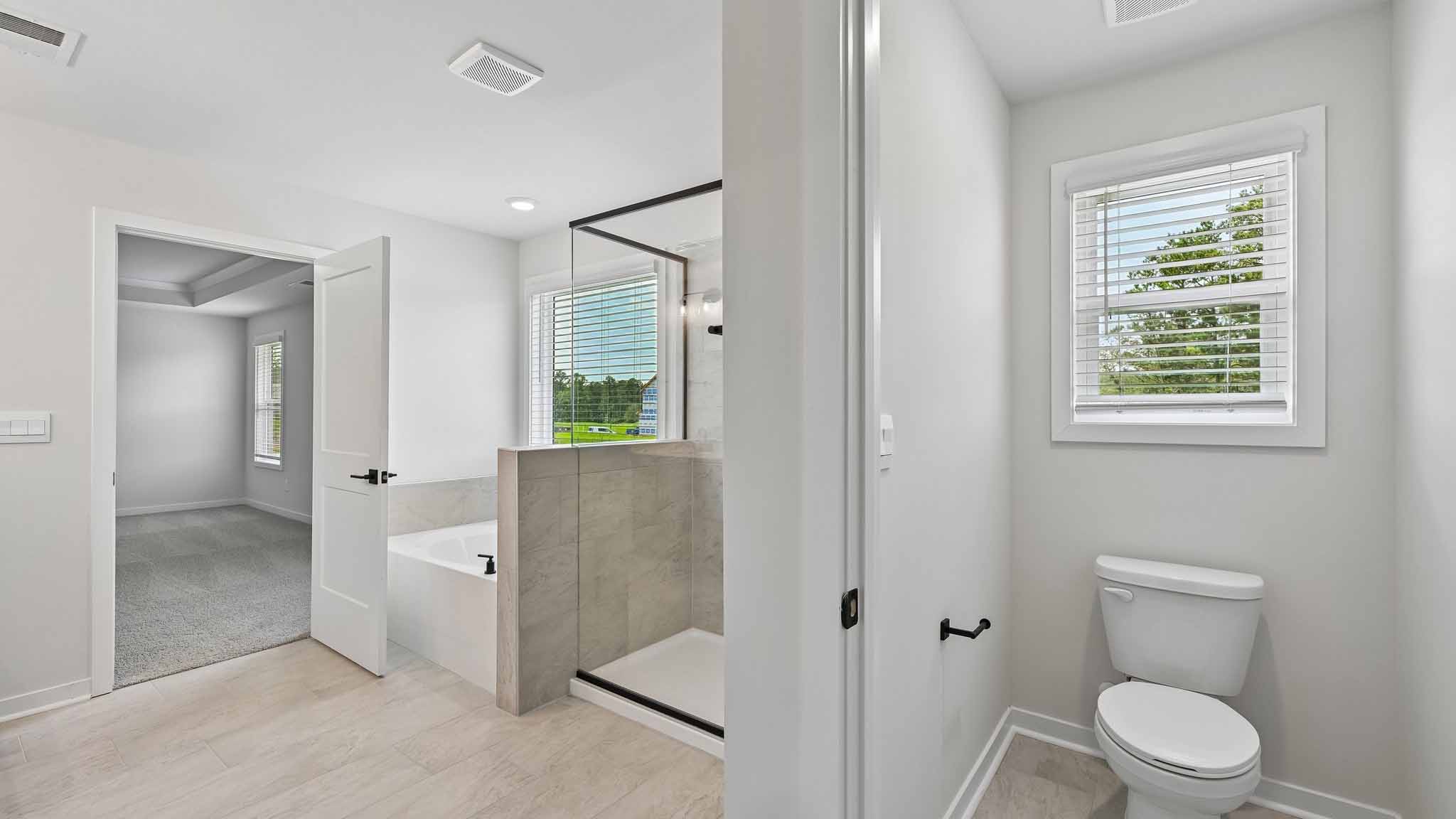 Primary bathroom with brown cabinets and standing tub and standing glass shower