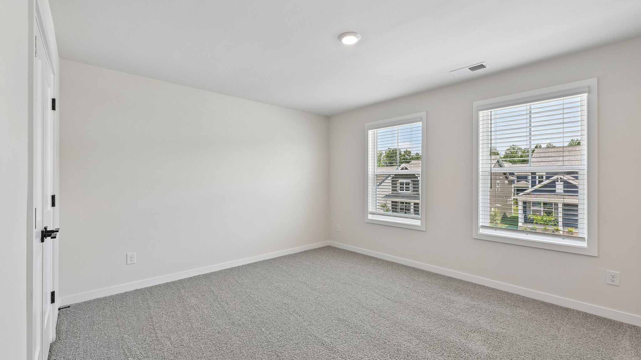 Carpeted bedroom with windows