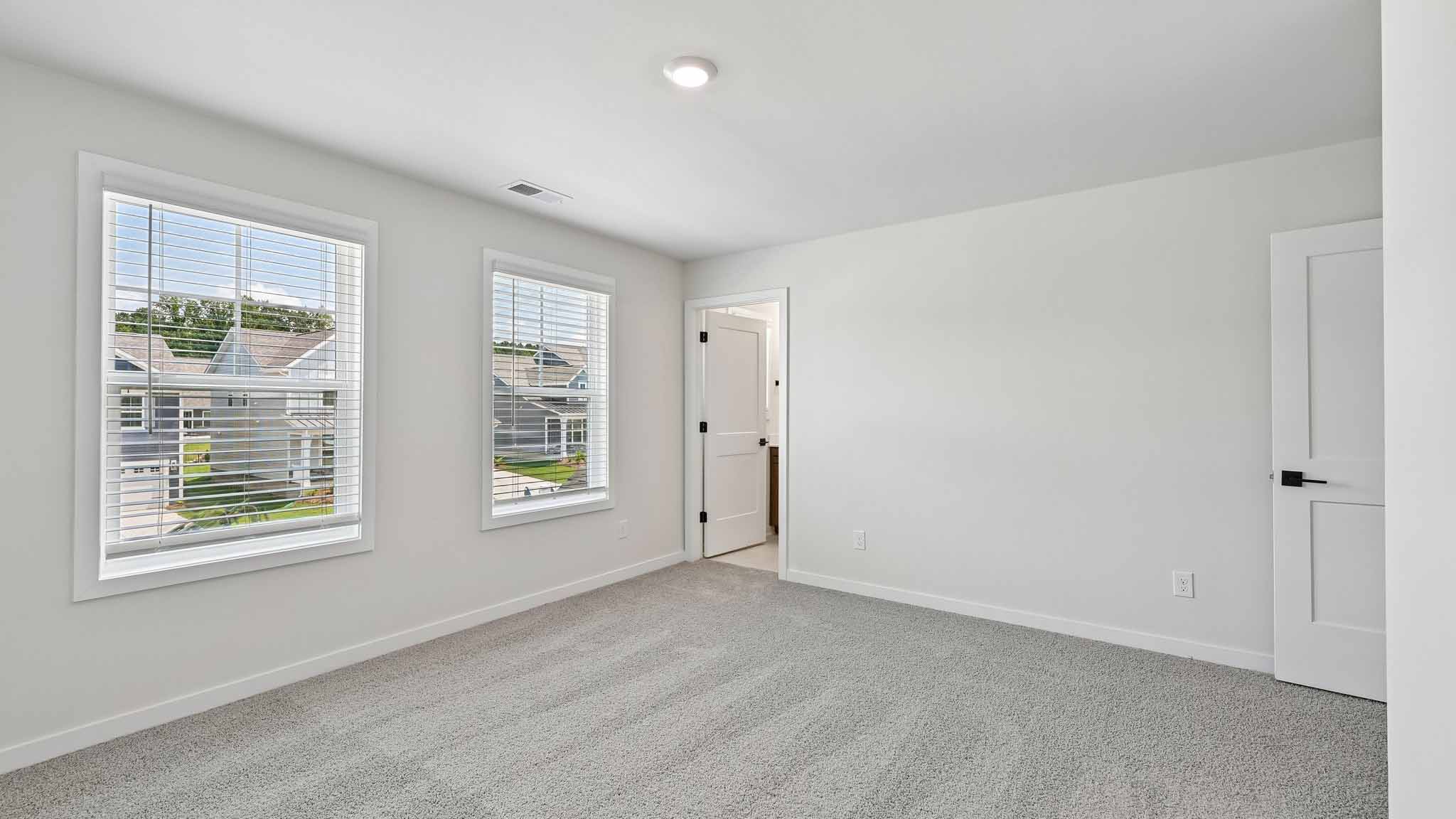 Carpeted bedroom with windows