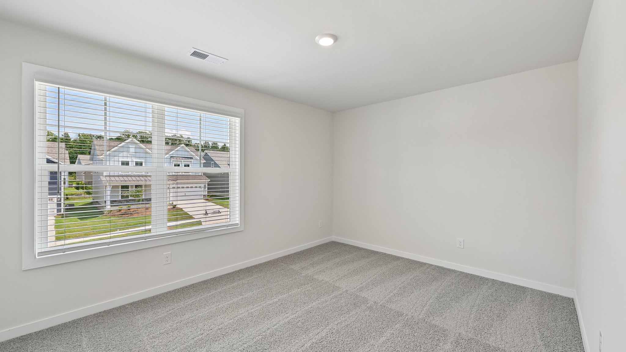 Carpeted bedroom with windows