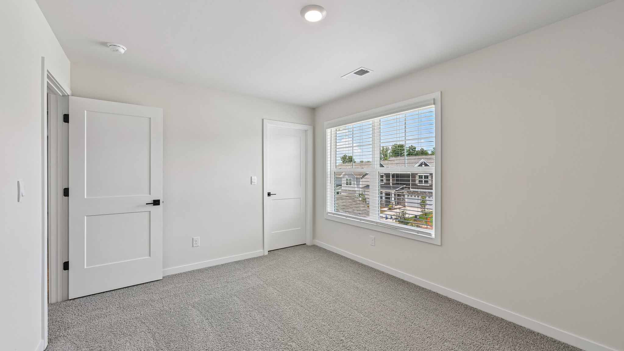 Carpeted bedroom with windows