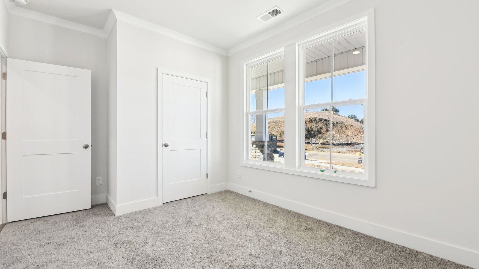Carpeted bedroom with large window
