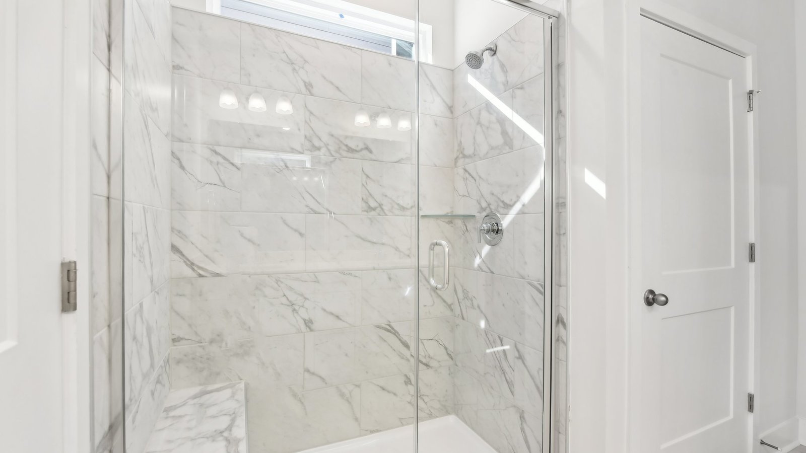 Primary bathroom  with double sink vanity, white counters and cabinets, and standing glass door shower
