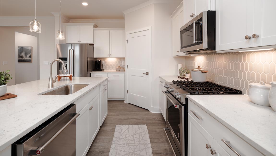 Kitchen and island with white cabinets and stainless steel appliances