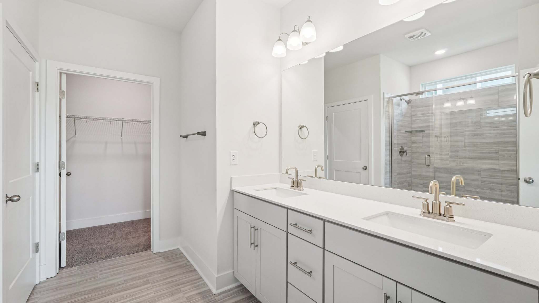 Primary bathroom with large counters and glass shower door