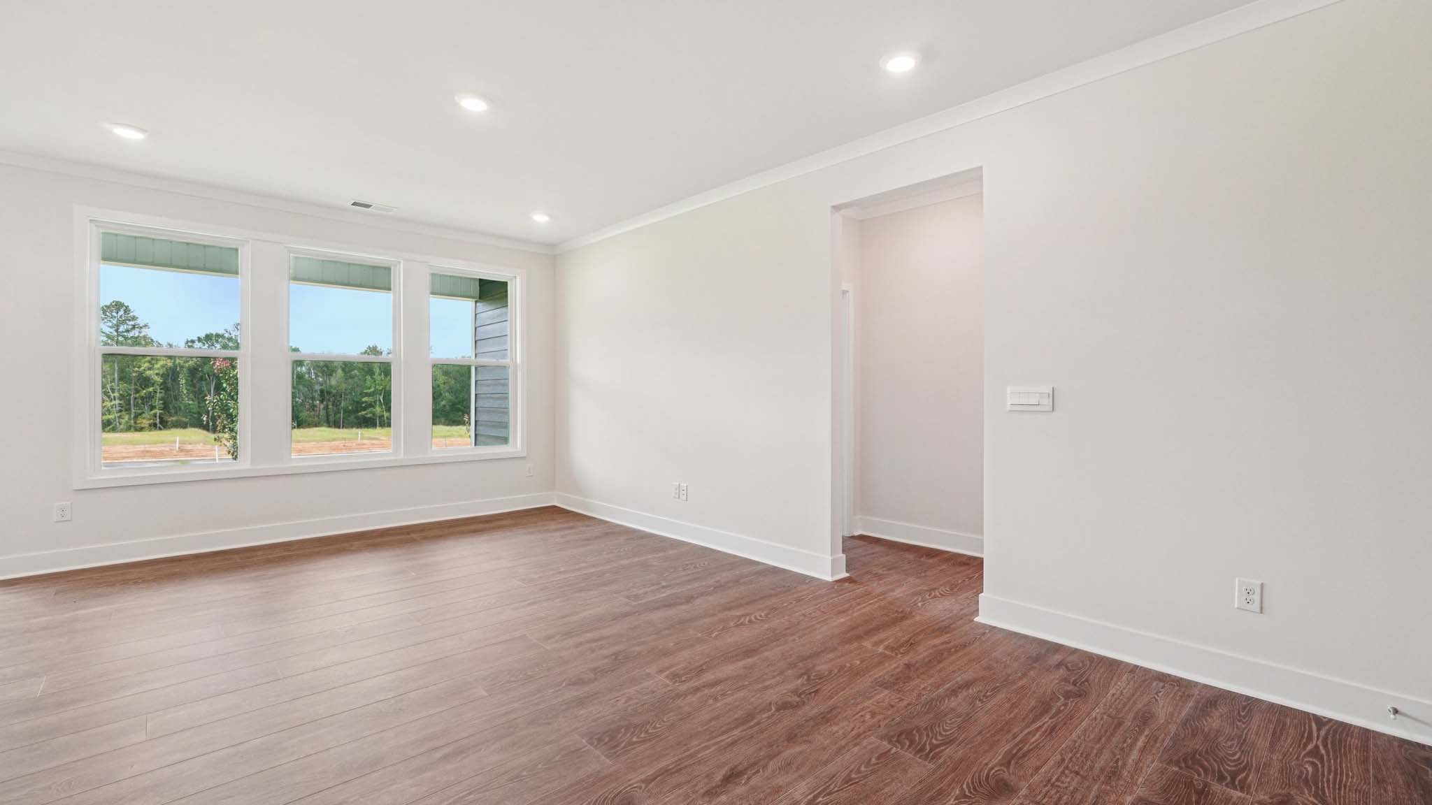 Open concept living room beside kitchen with large windows