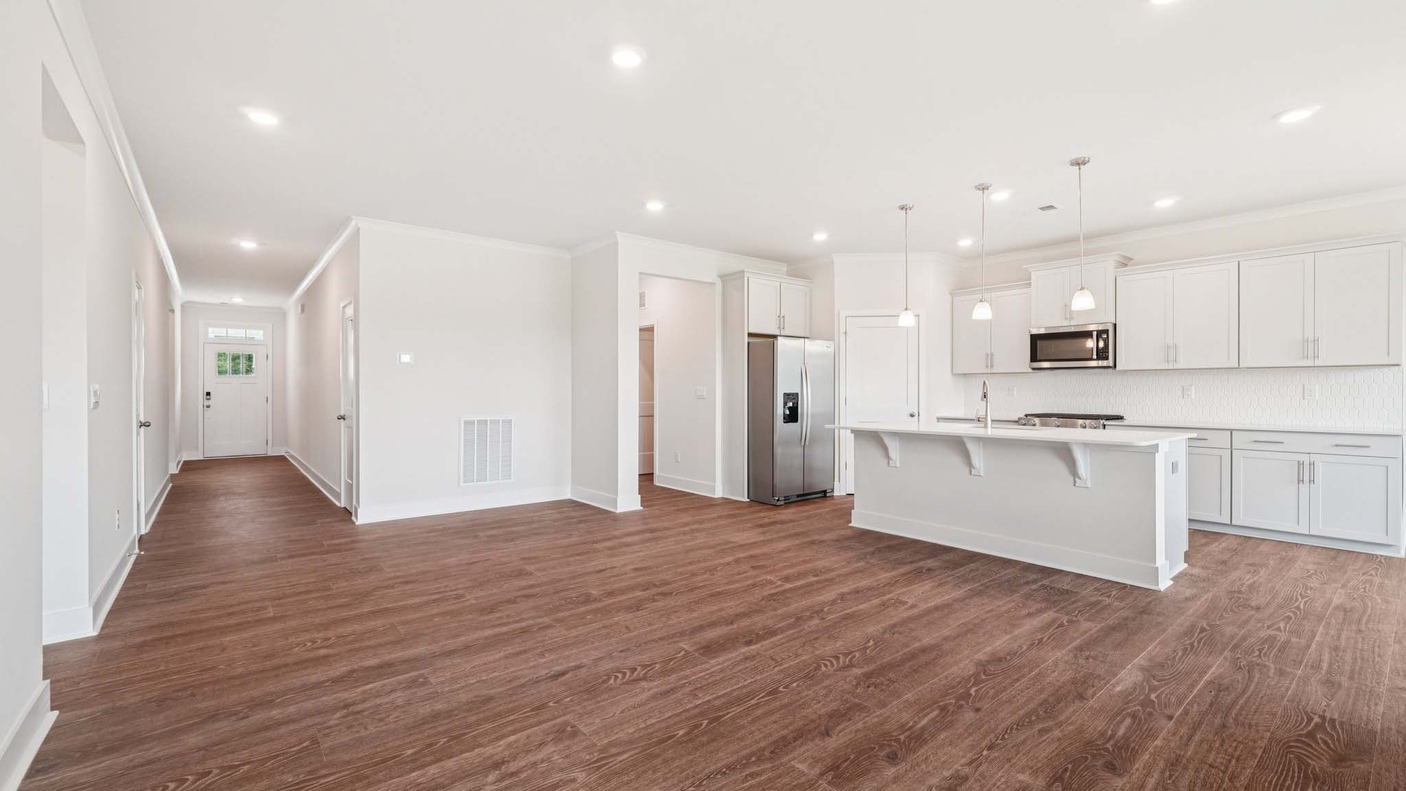 Open concept living room beside kitchen with large windows