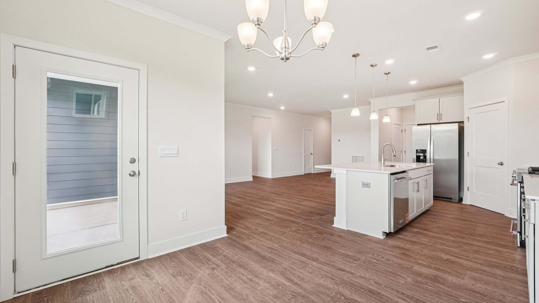 Open concept living room beside kitchen with large windows
