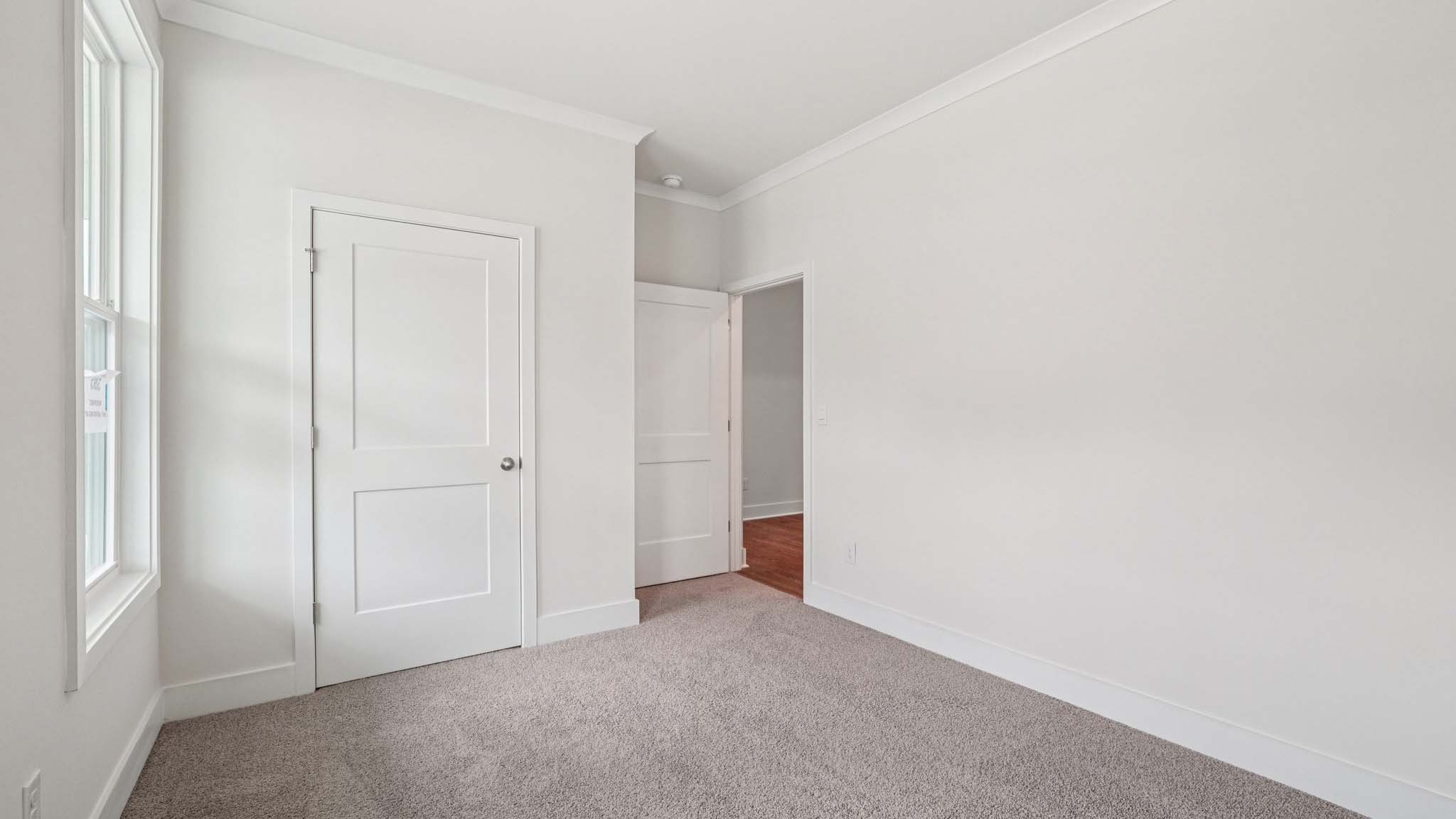 Carpeted bedroom with large window
