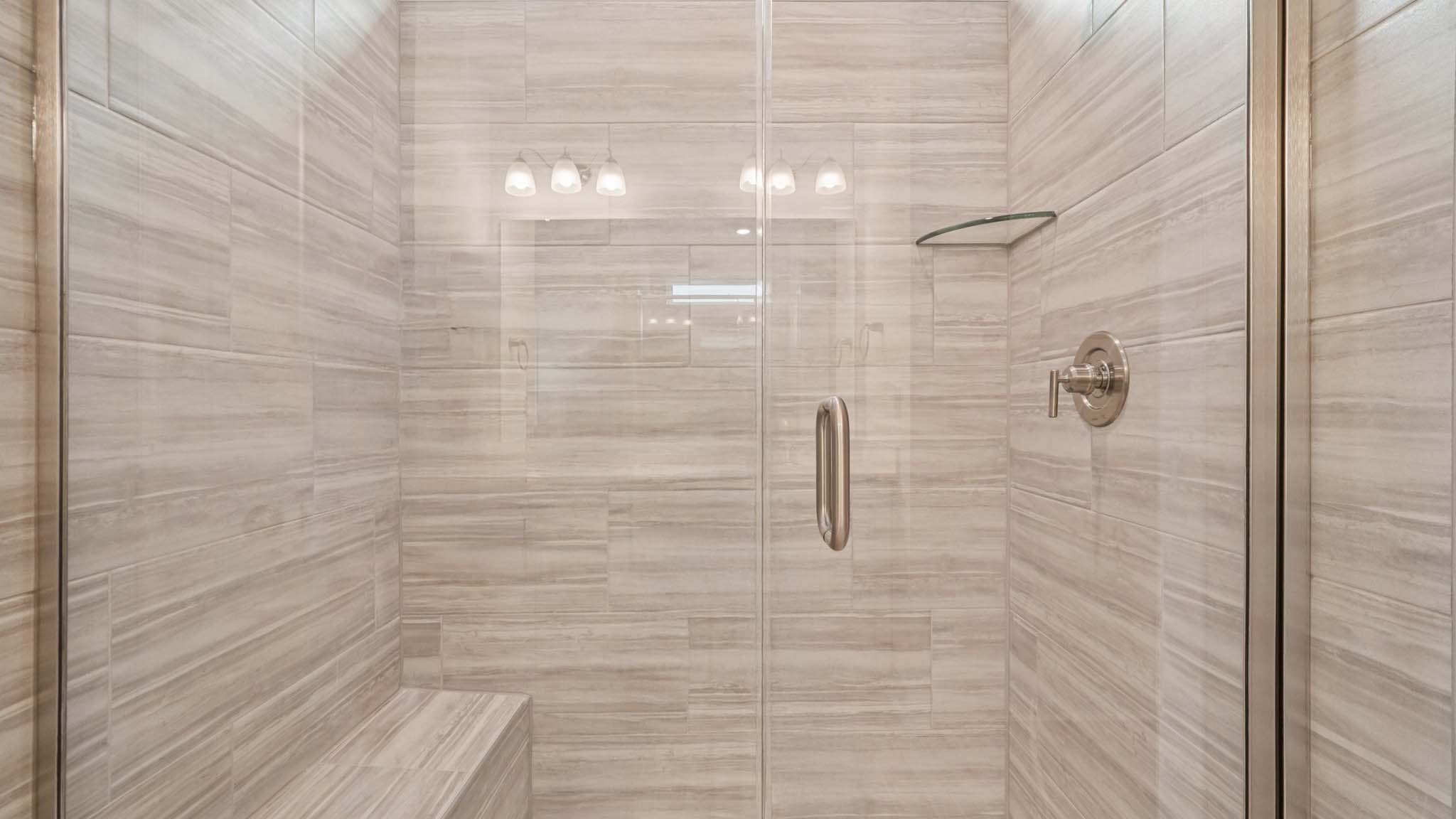 Primary bathroom with large counters and glass shower door