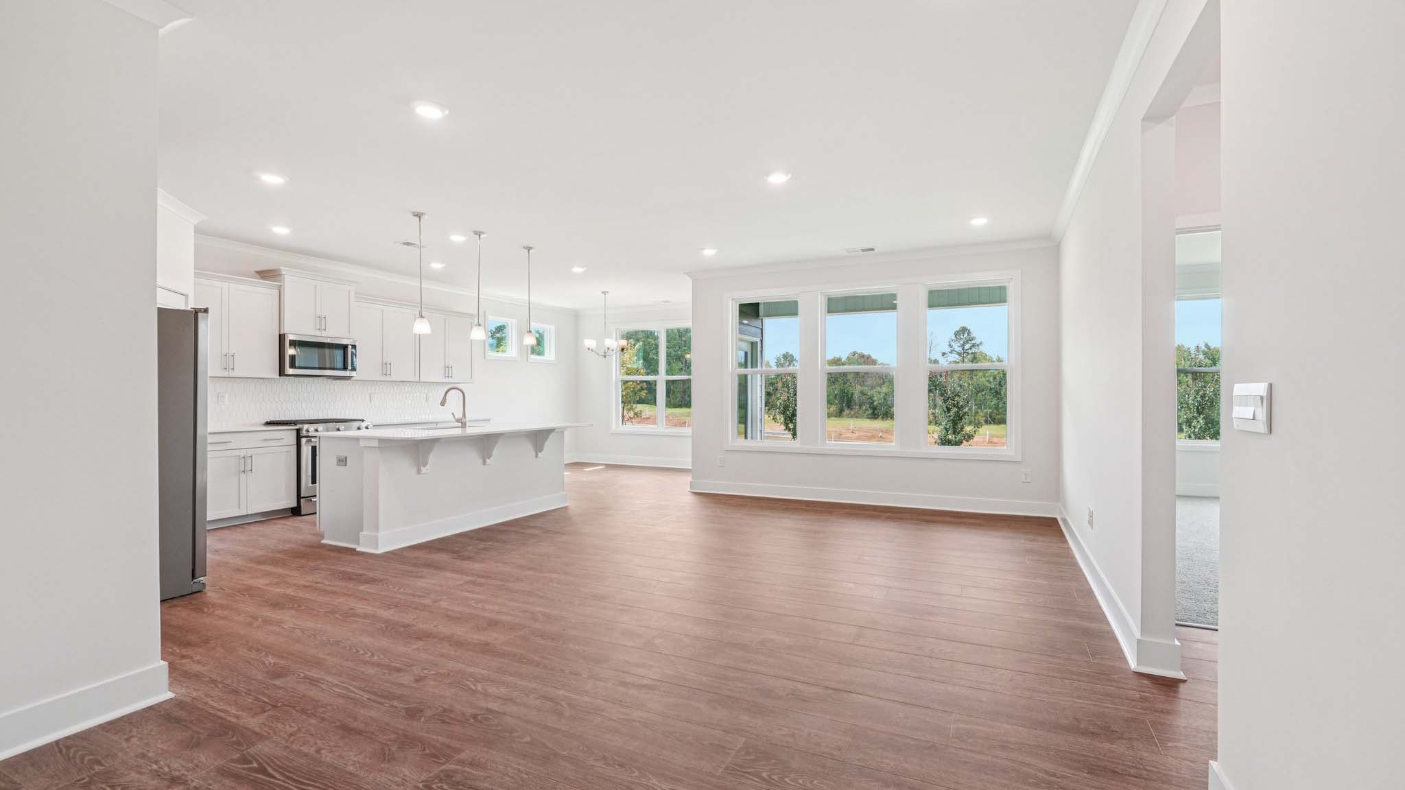 Open concept living room beside kitchen with large windows
