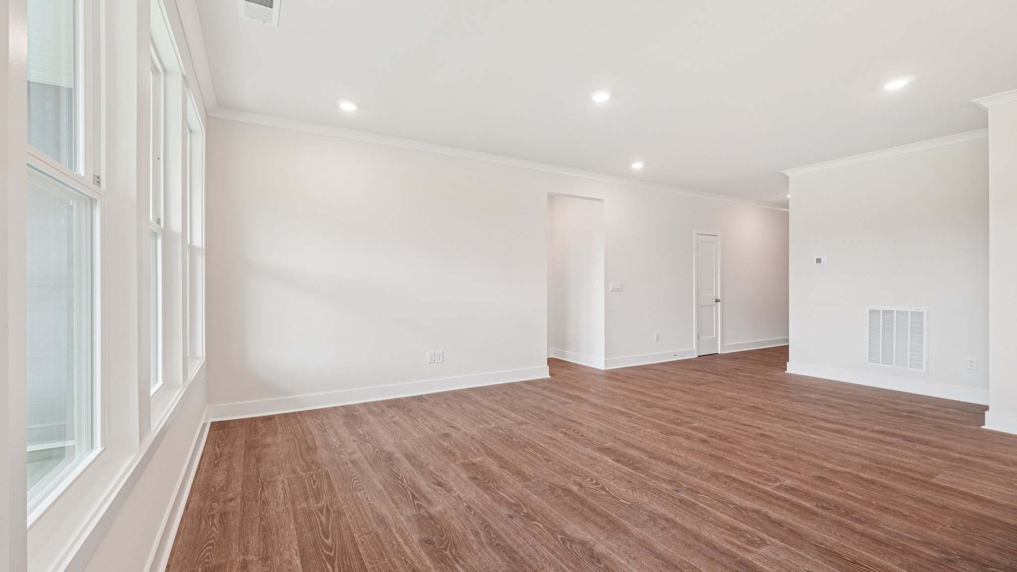 Open concept living room beside kitchen with large windows