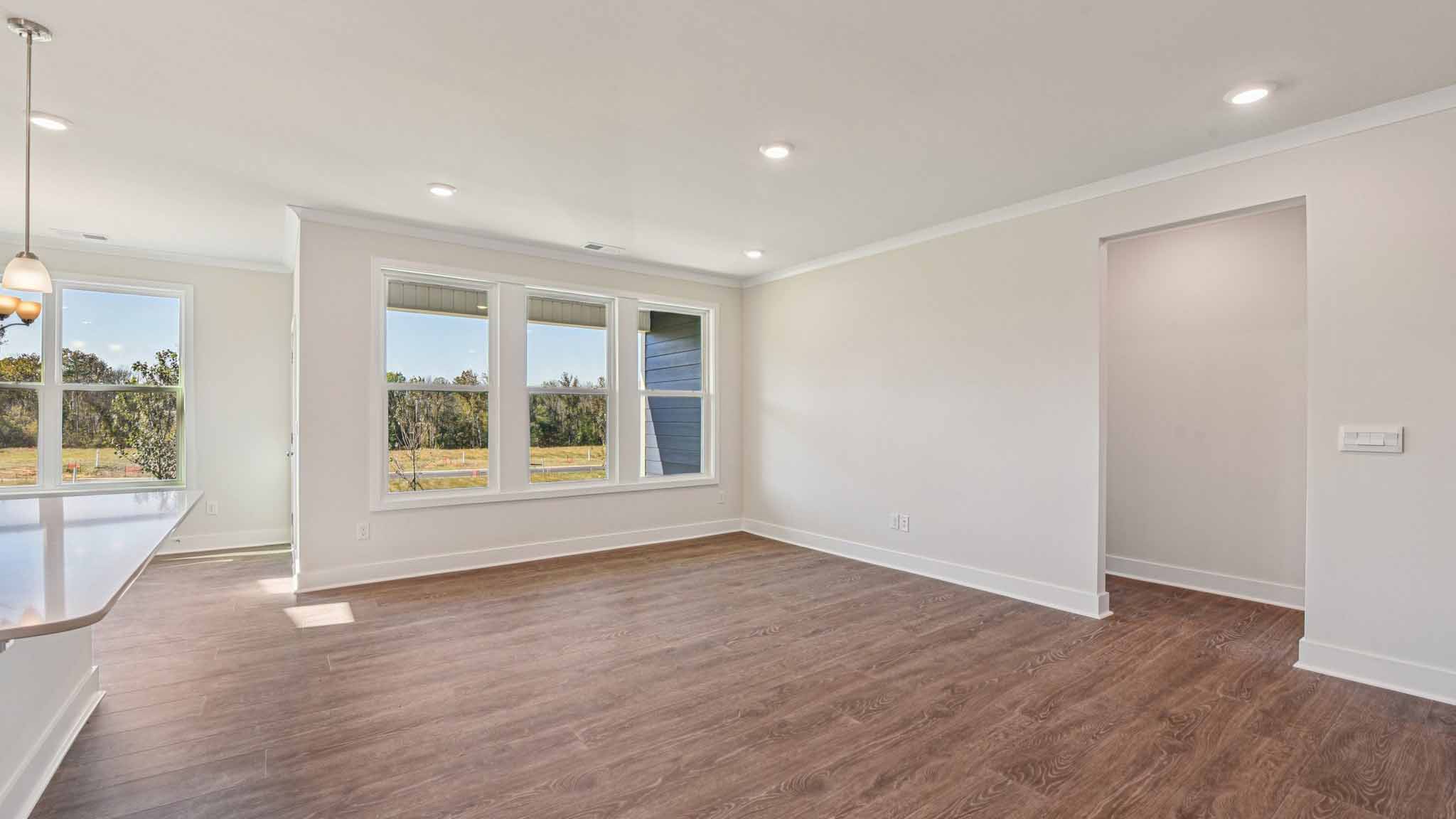 Open concept living room beside kitchen with large windows