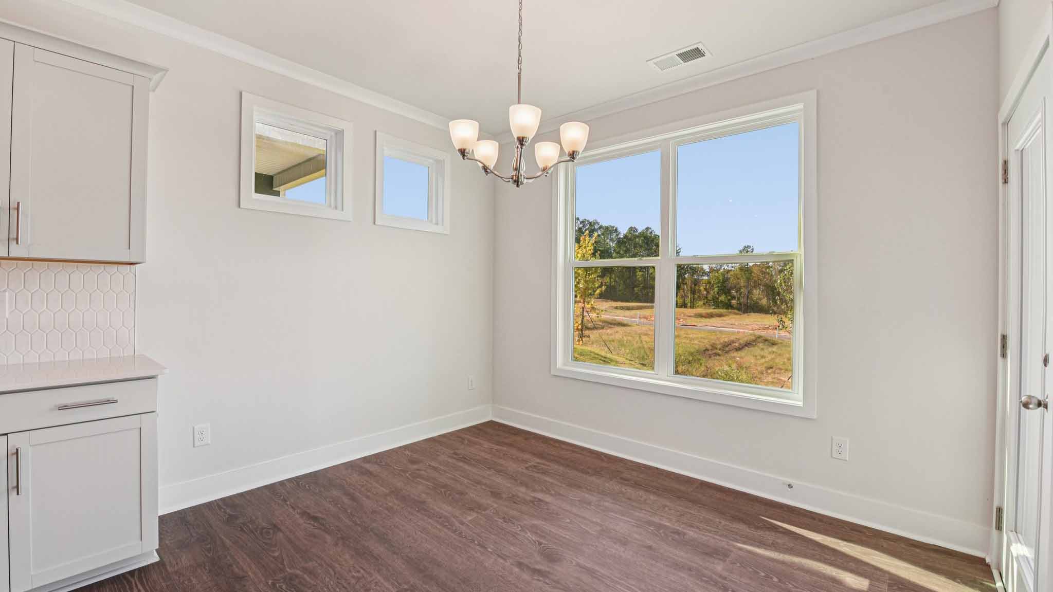 Open concept living room beside kitchen with large windows
