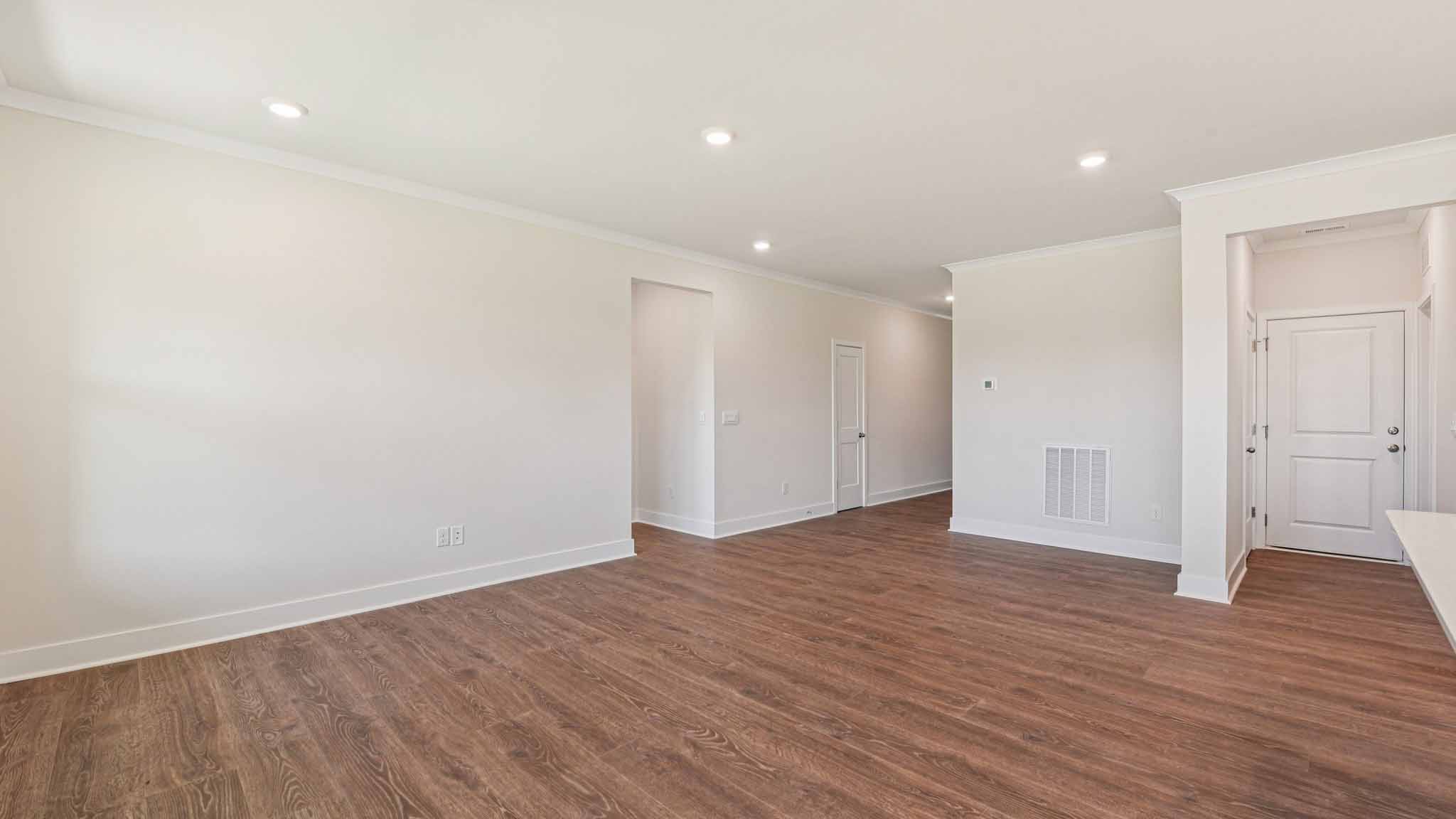 Open concept living room beside kitchen with large windows