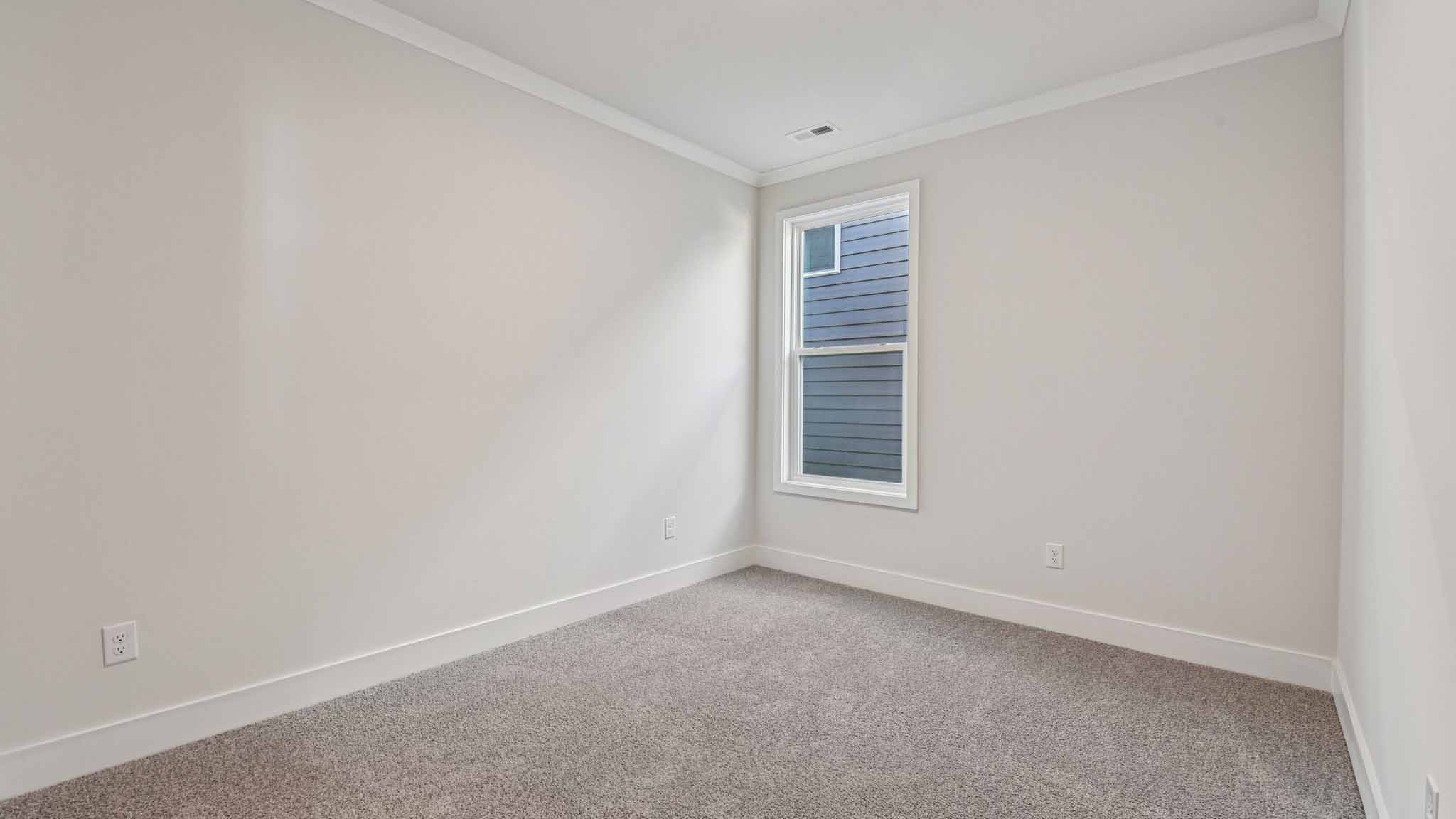 Carpeted bedroom with large window