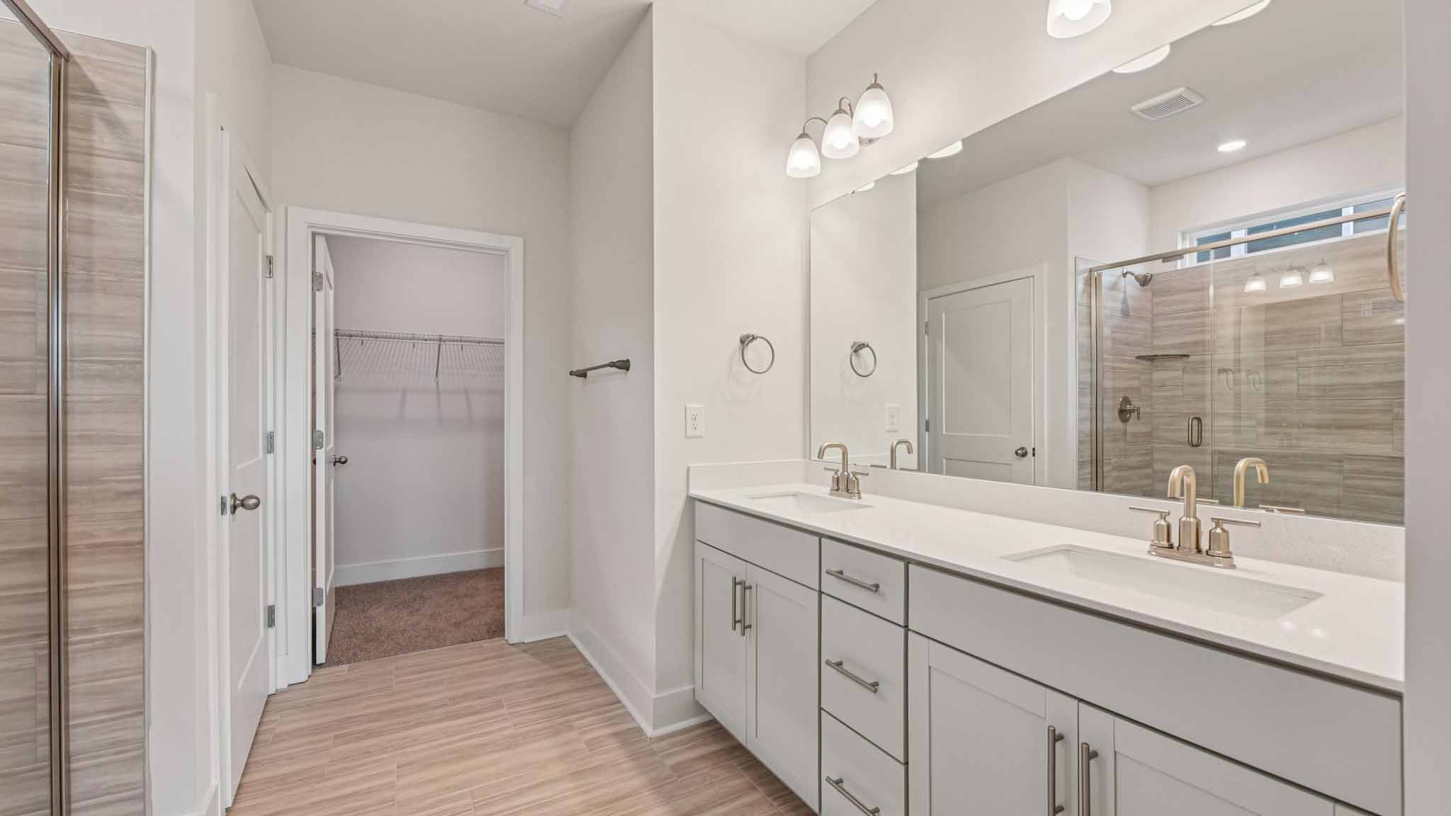 Primary bathroom with large counters and glass shower door
