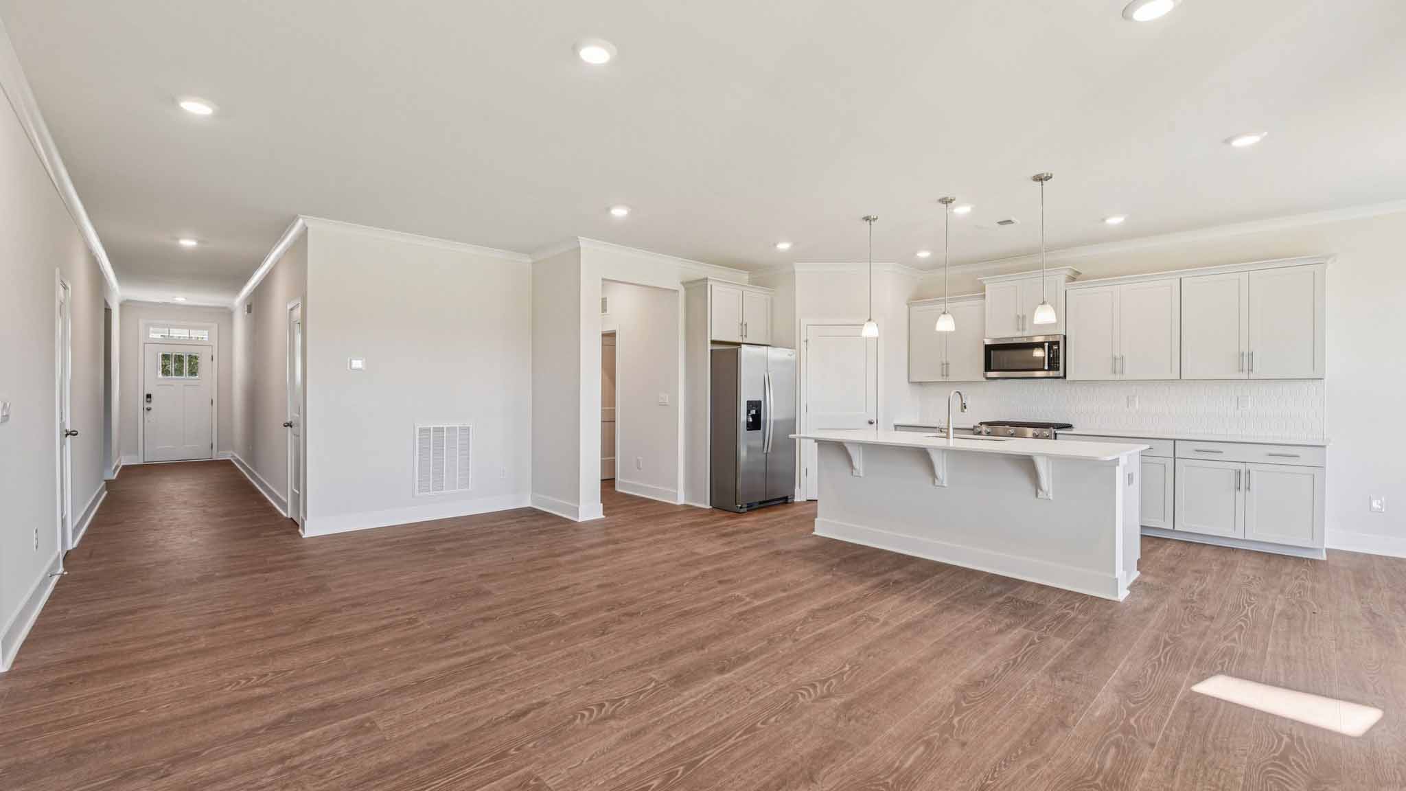 Open concept living room beside kitchen with large windows