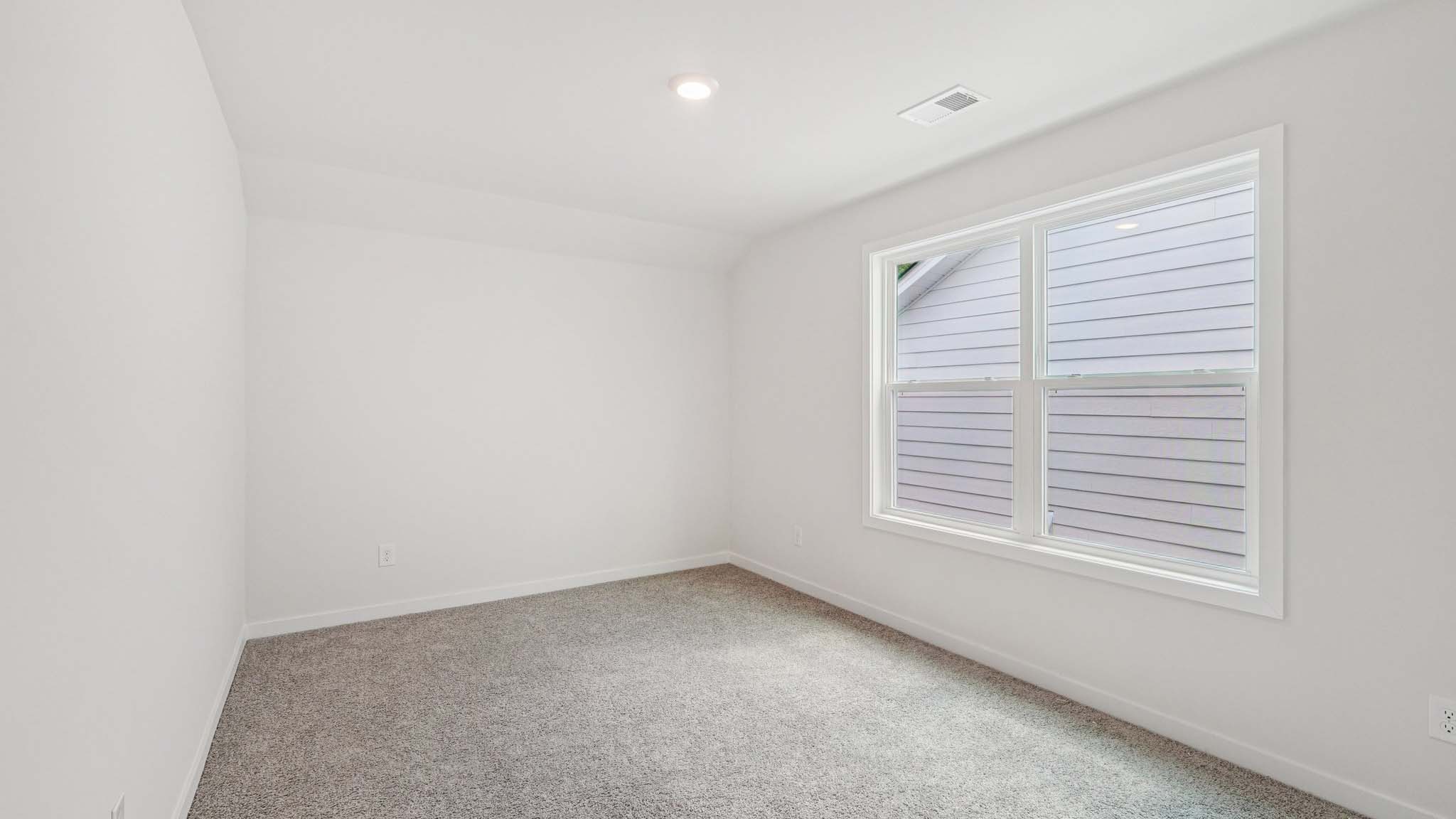 Carpeted bedroom with large windows