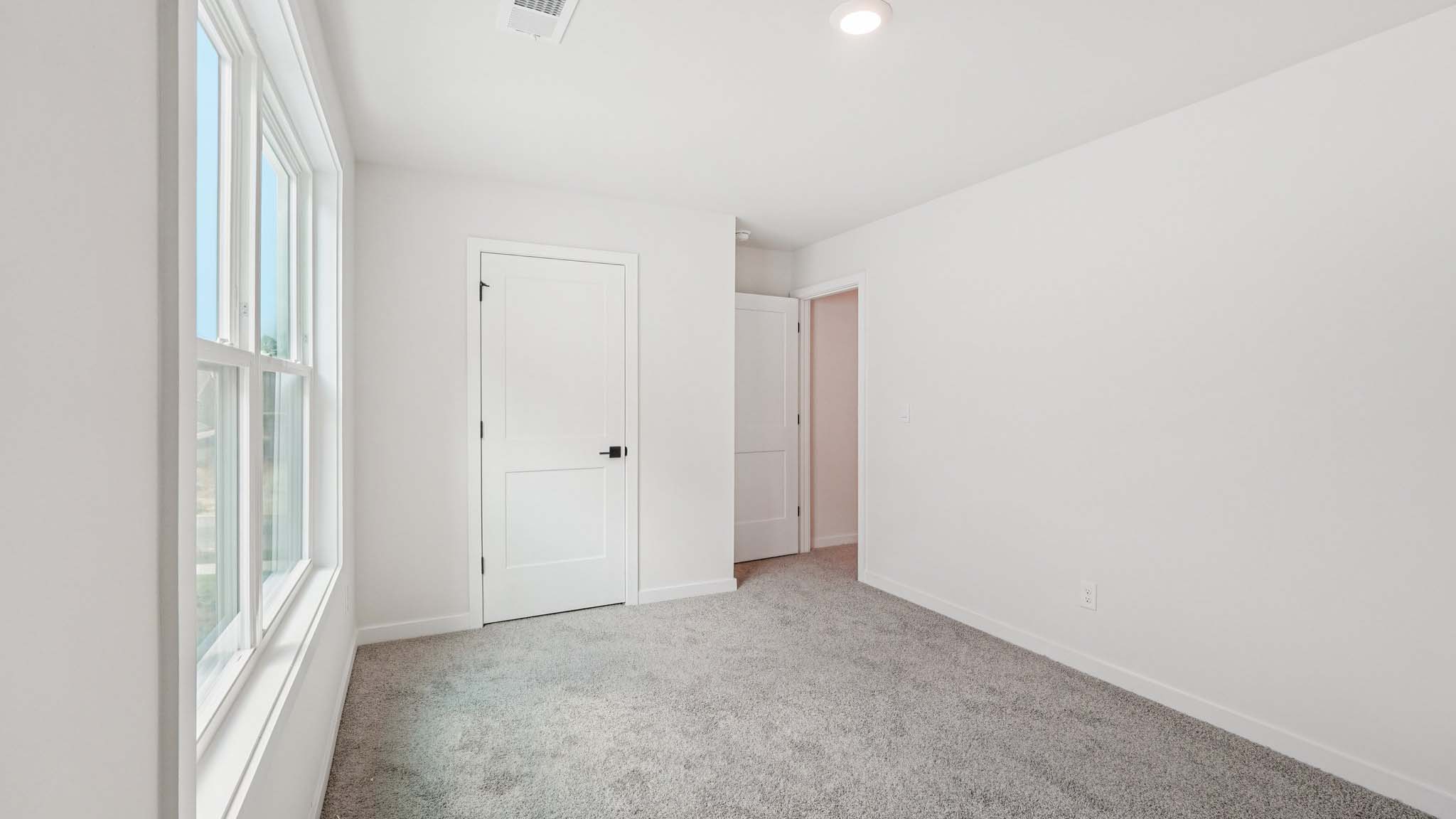 Carpeted bedroom with large windows