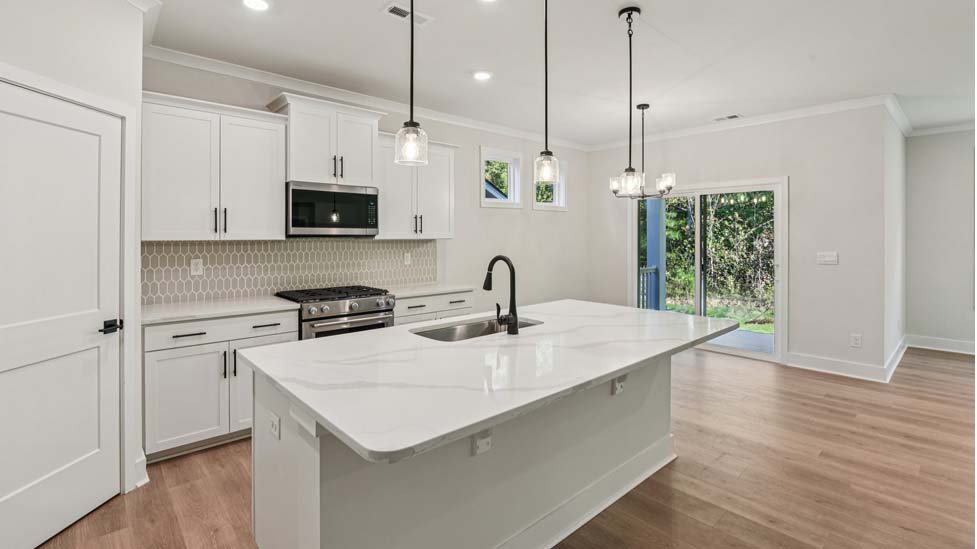 Kitchen and island with grey cabinets, white countertops, and stainless steel appliances