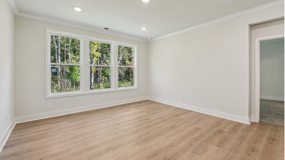 Living room with three large windows, beside dining area
