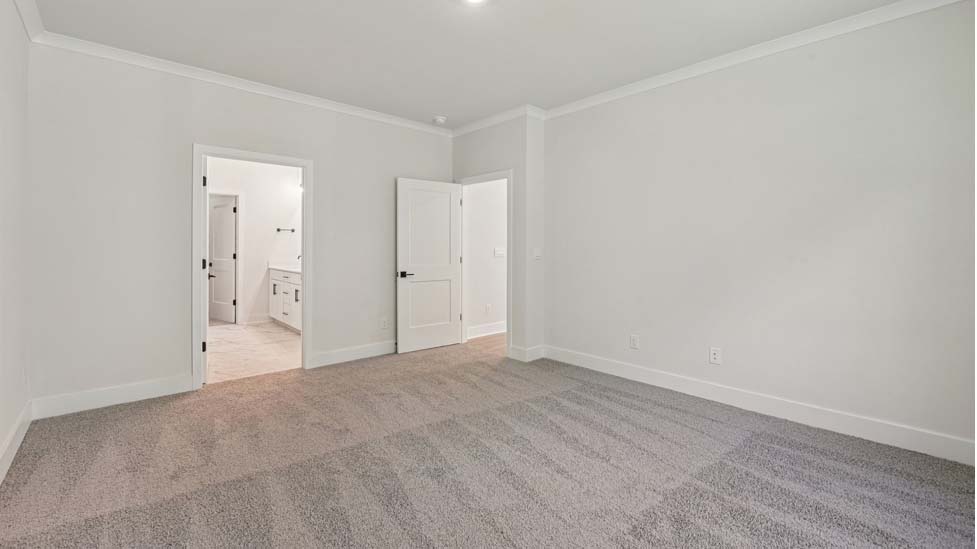 Primary carpeted bedroom with large windows