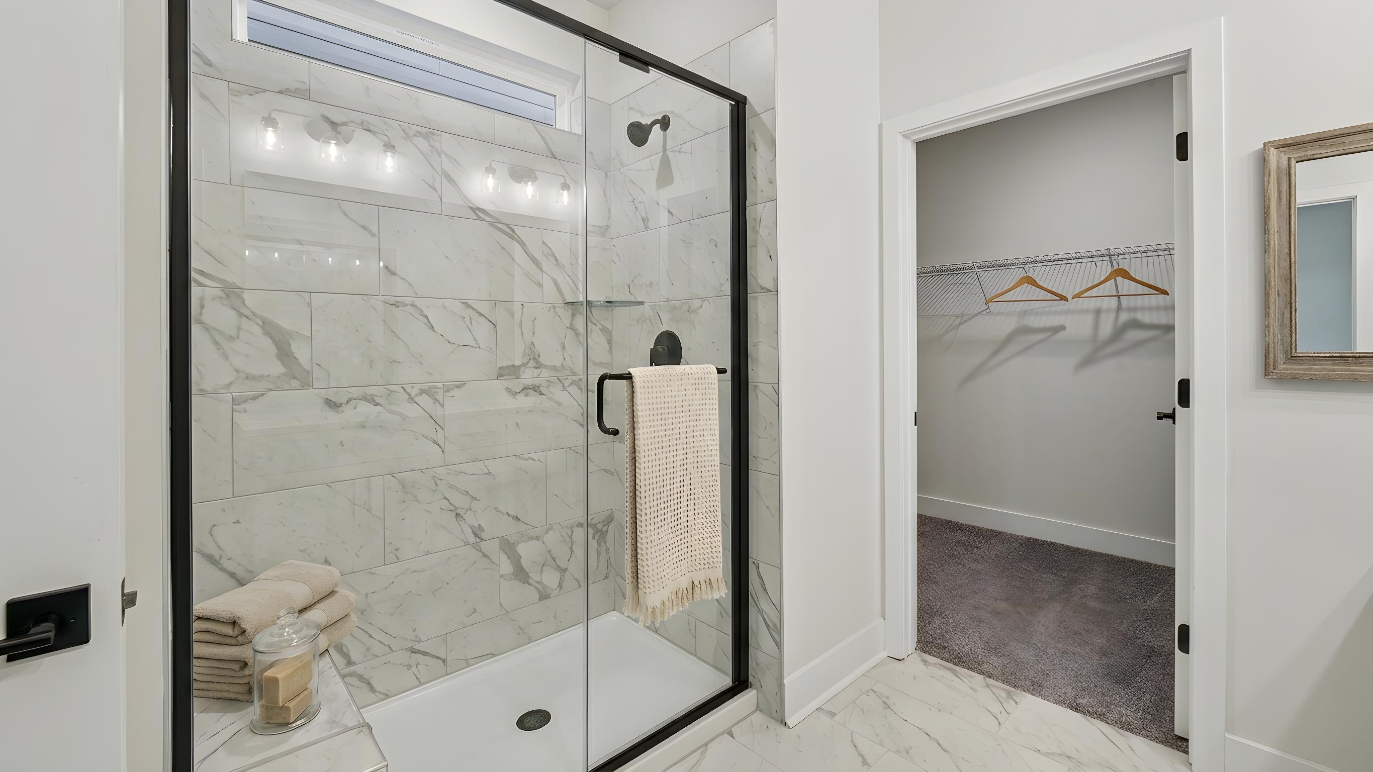 Primary bathroom with double sink vanity, large shower, and attached walk in closet