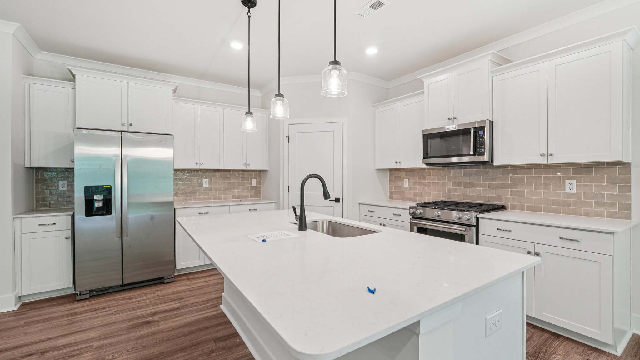 Kitchen and Island with white cabinets and stainless steel appliances