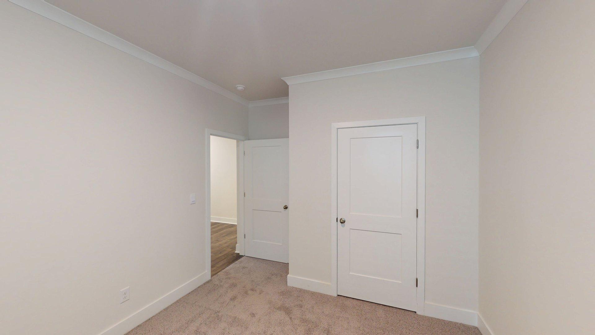 Carpeted bedroom with large windows