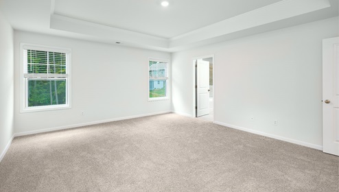 Large carpeted bedroom with three windows