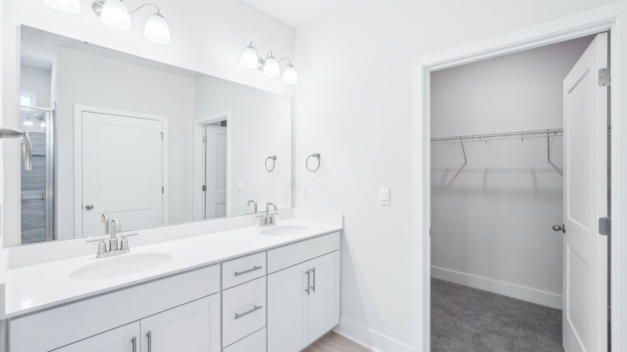 bathroom with double sink vanity and large shower