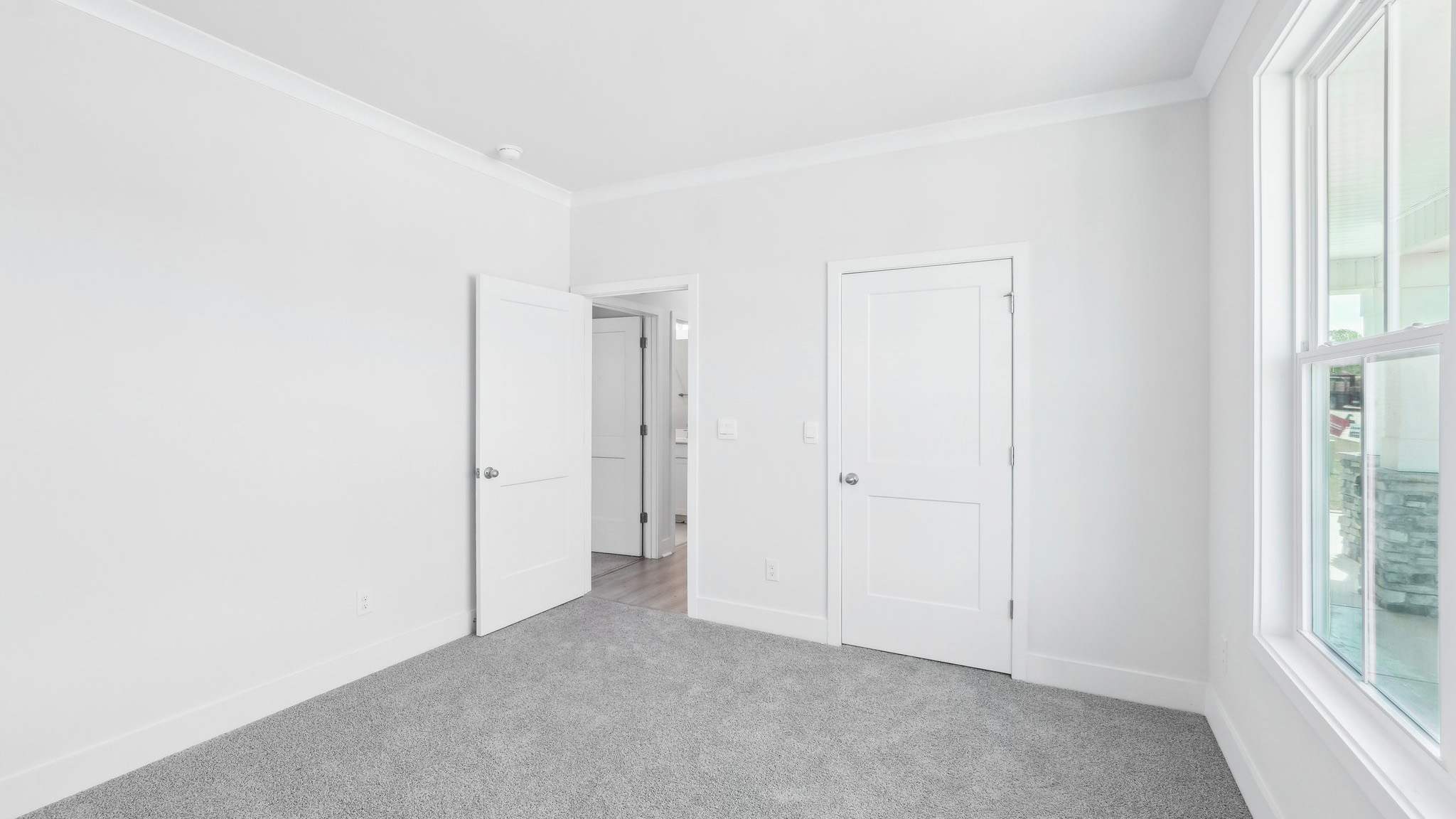 Carpeted bedroom with large window