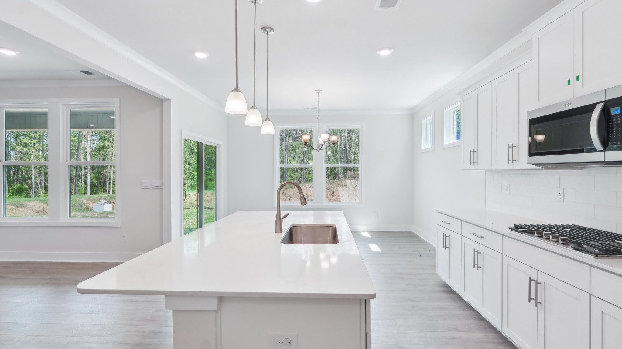 Kitchen and island with hanging lights, subway tile backsplash, and stainless steel appliances