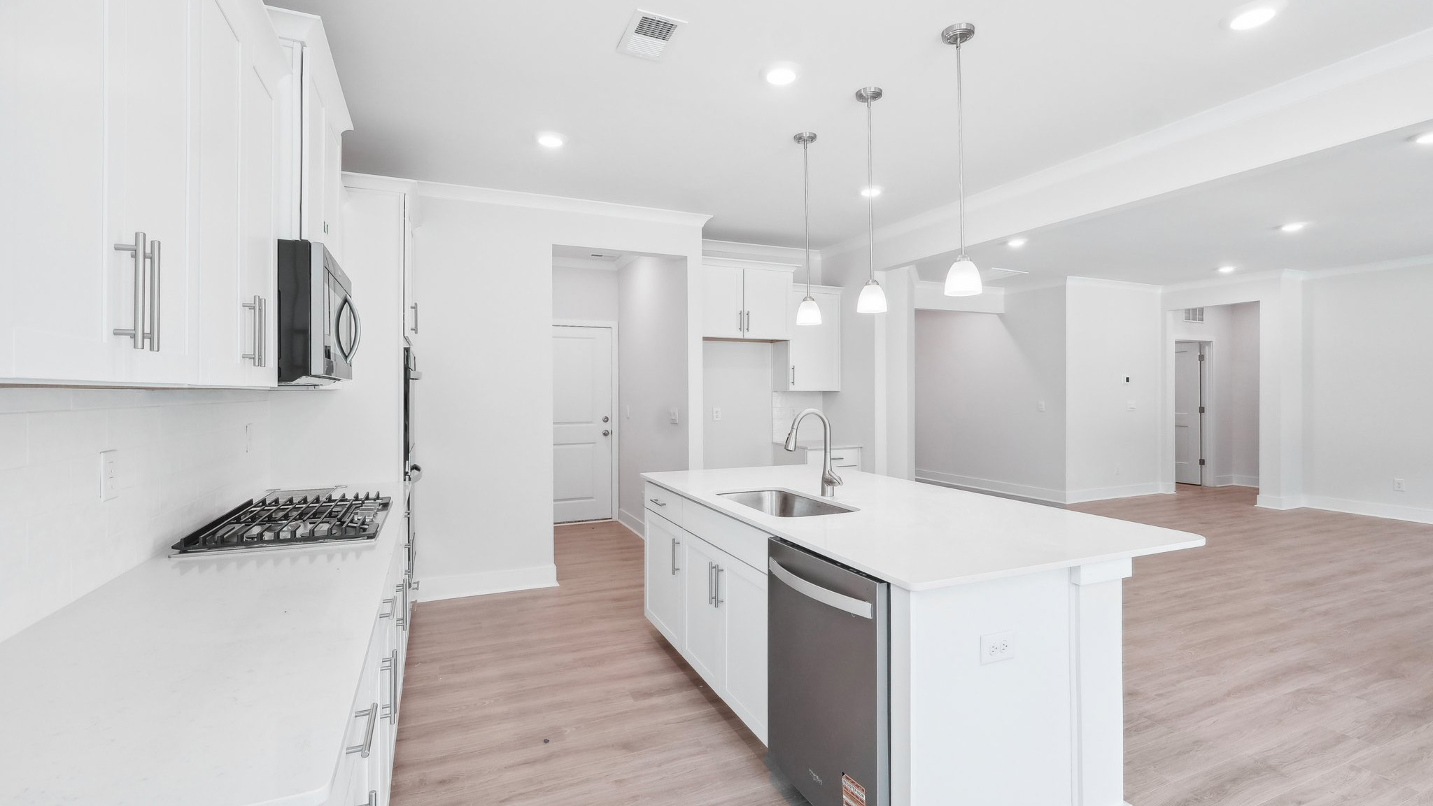 Kitchen and island with hanging lights, subway tile backsplash, and stainless steel appliances