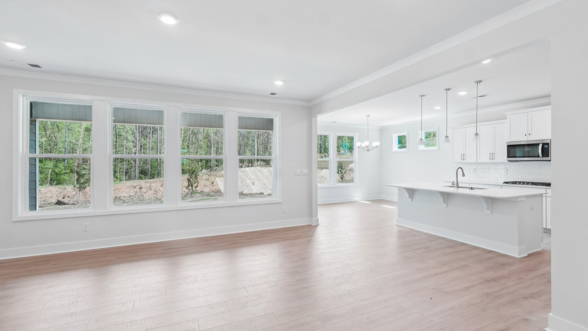 Large open family room beside kitchen with large windows