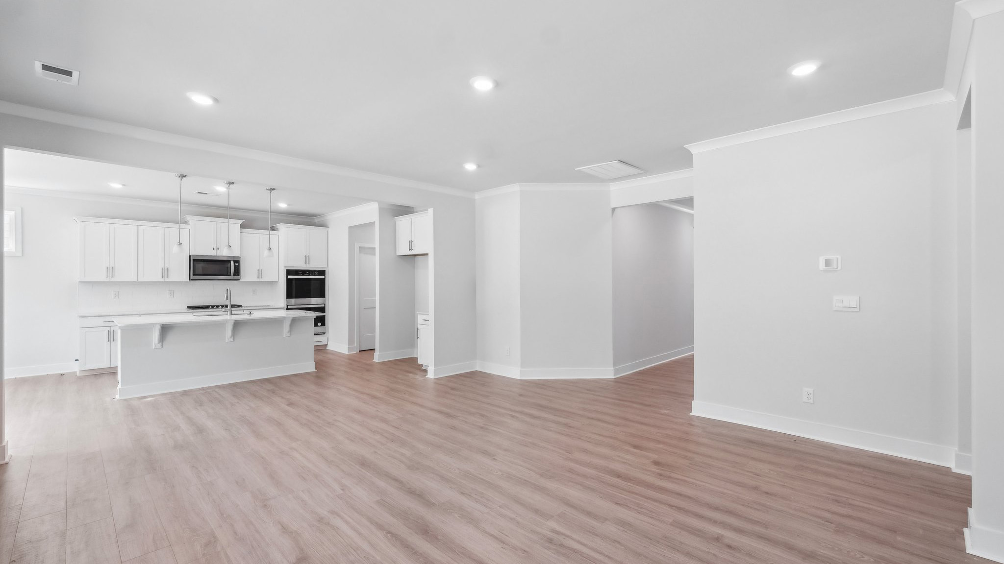 Large open family room beside kitchen with large windows