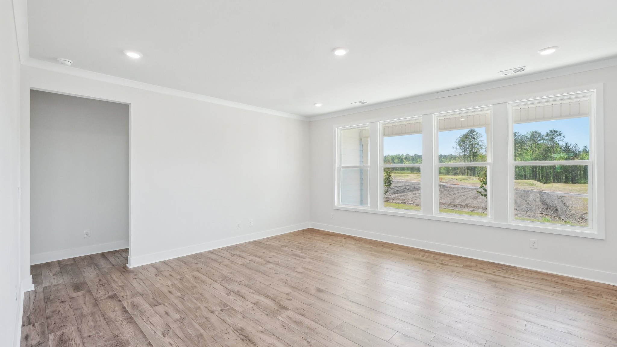 Large open family room beside kitchen with large windows